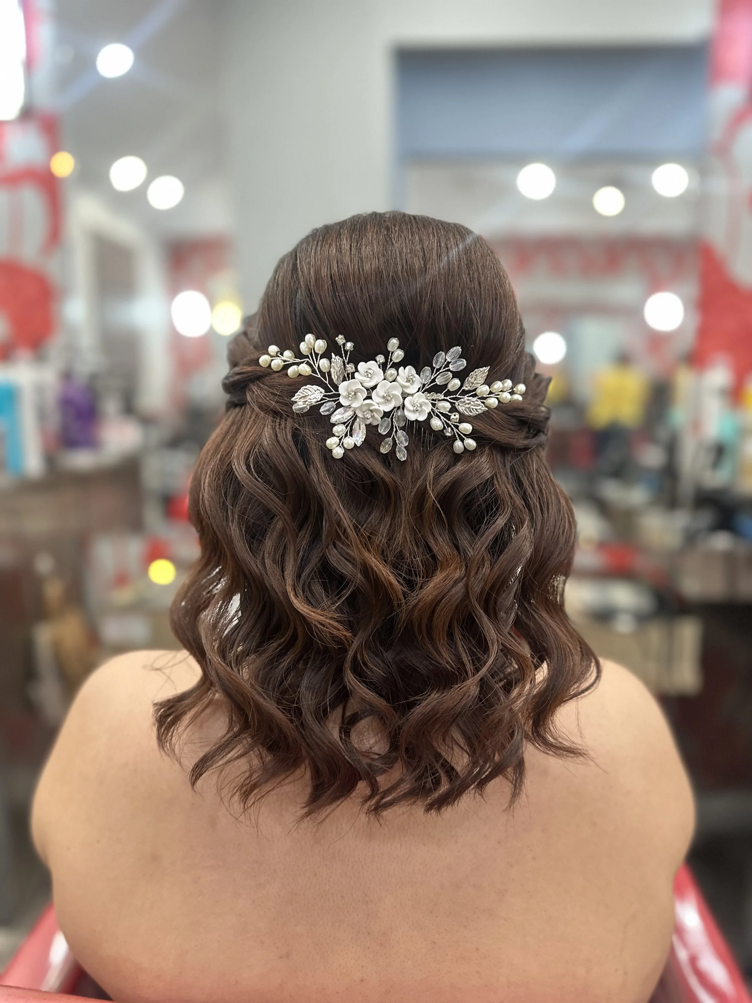 Half-up half-down wedding hairstyle for shoulder-length wavy brunette hair.