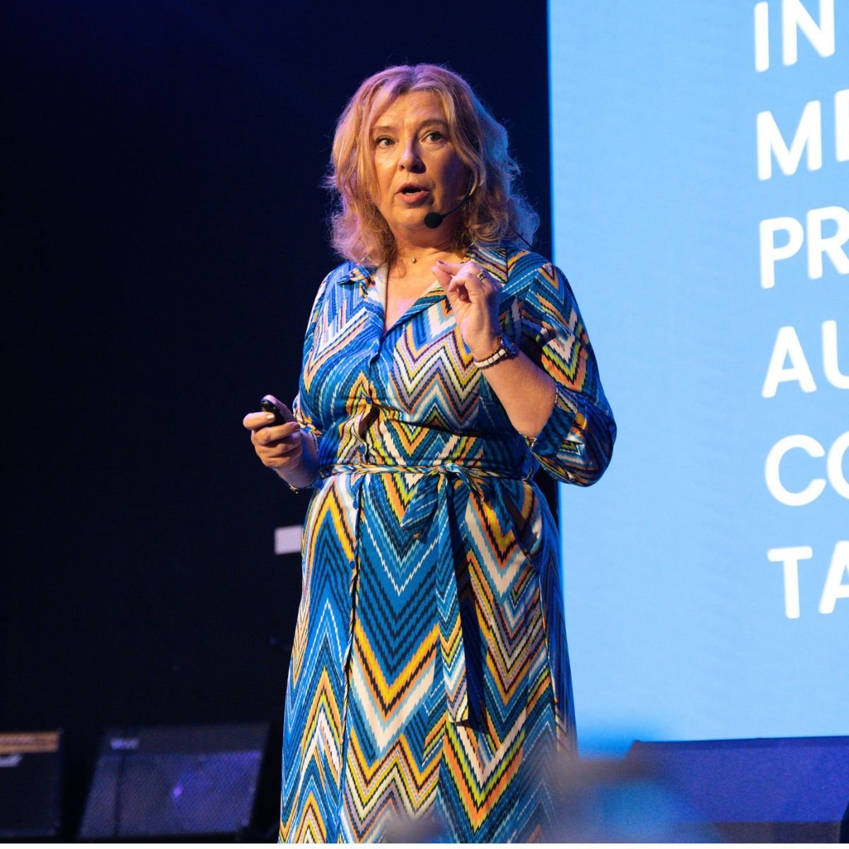 Maureen McCowen presenting on stage at a conference — public speaking and presentation skills coach Ireland