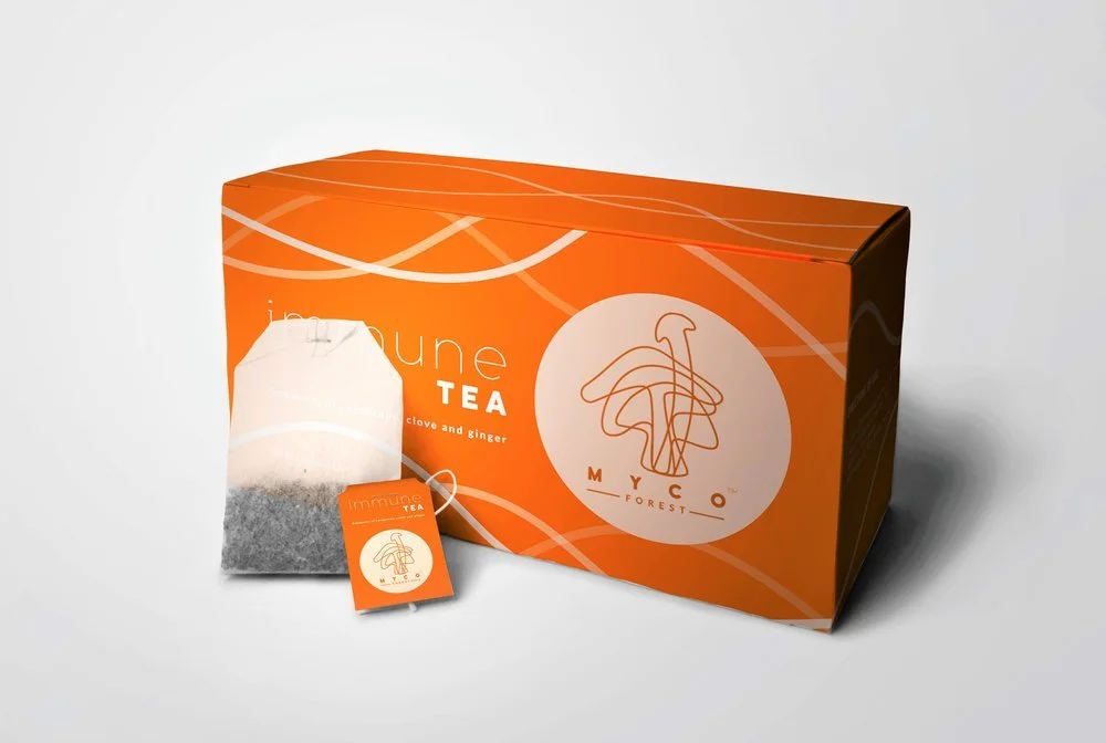Orange box of immune tea with a tea bag and tag, featuring a simple line drawing of a mushroom and the words "immune tea" on the packaging.