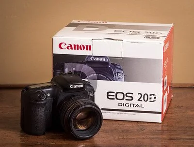 Canon EOS 20D digital camera with lens in front of its original box.