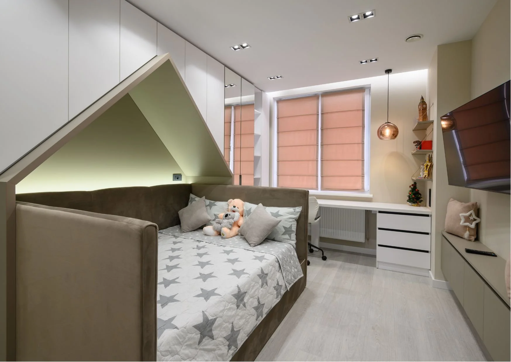 Contemporary bedroom with star bedding, desk, green accent lighting, and cozy design.