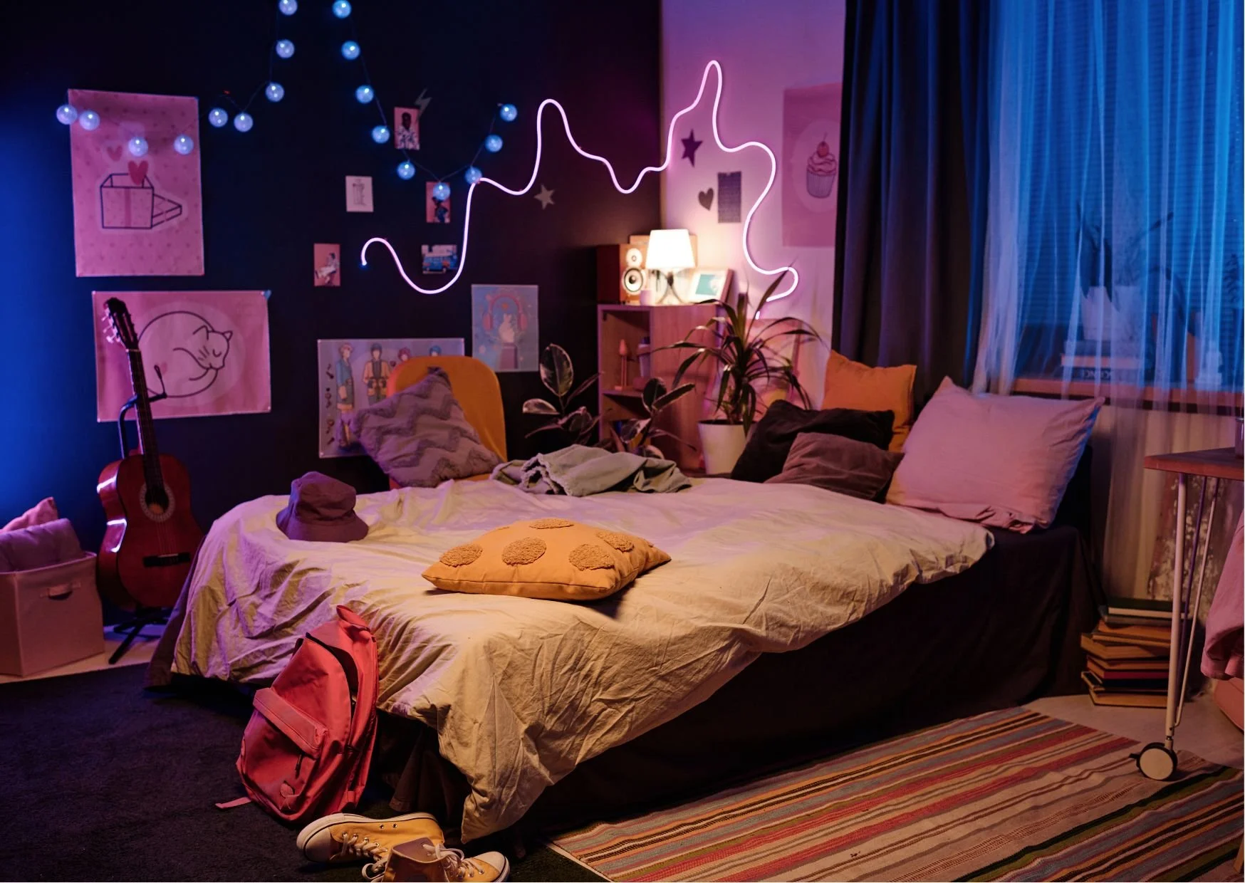 Warm bedroom with colorful lighting, guitar, posters, and vibrant cozy atmosphere.