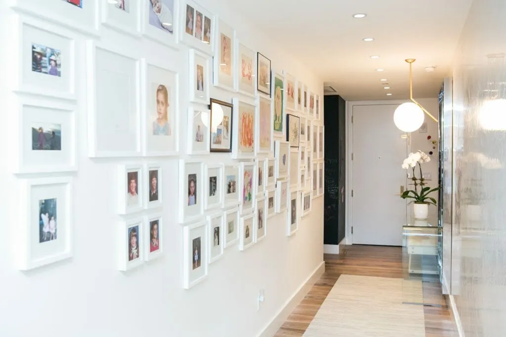 Bright hallway with family photo gallery wall and orchid console table.