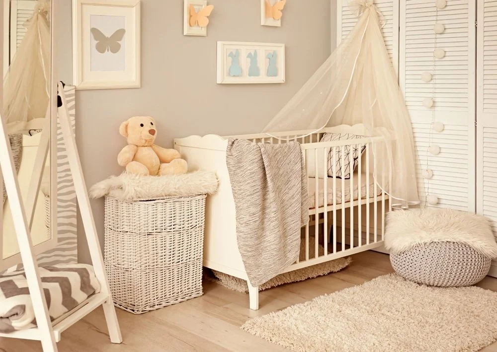 Soft neutral nursery with crib, armchair, woven textures, and cozy boho styling.