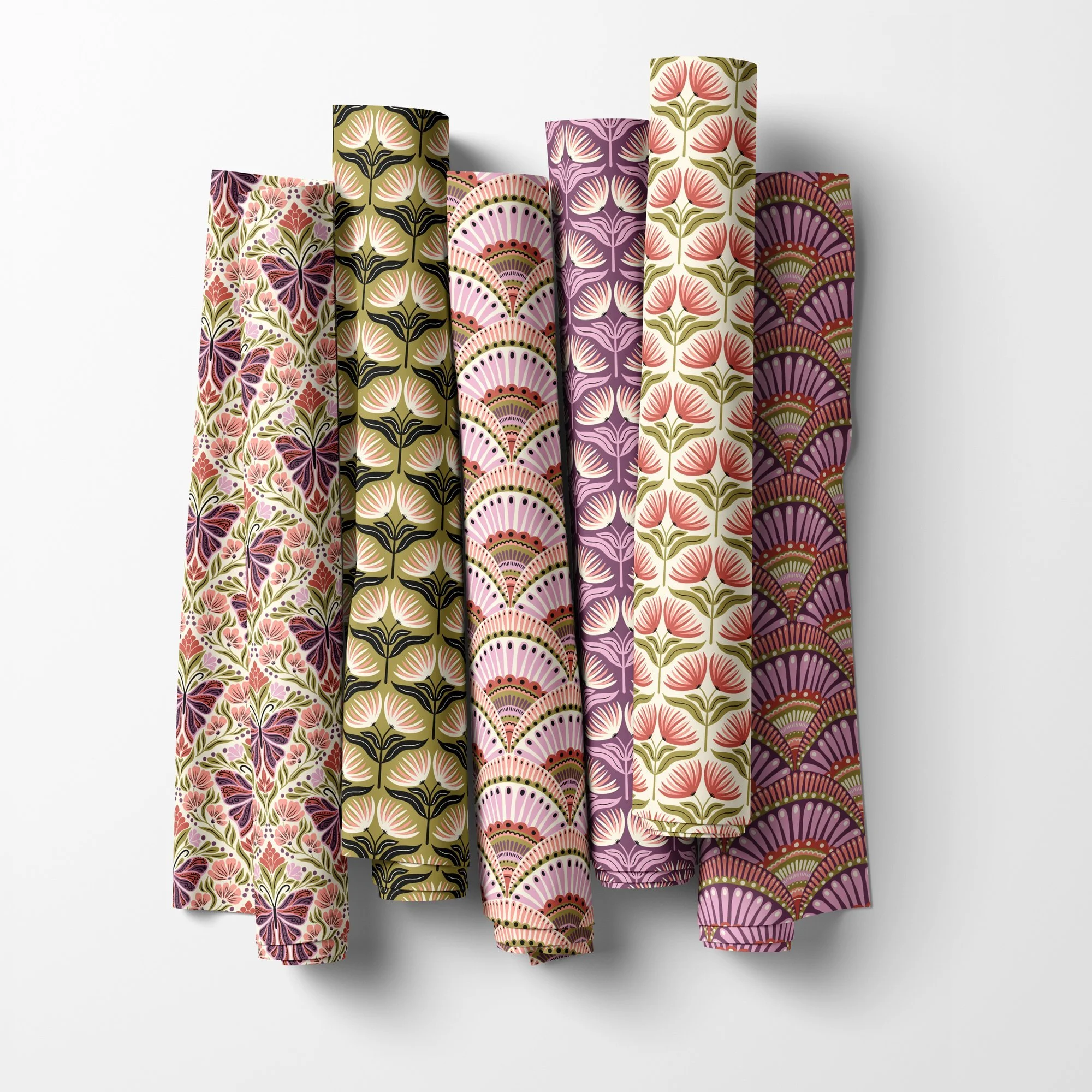 Fabric rolls mockup of the Butterfly Folk Garden collection by Sandra Hutter: butterfly damask, scallop fans and fan flowers in plum, blush, cream and olive green