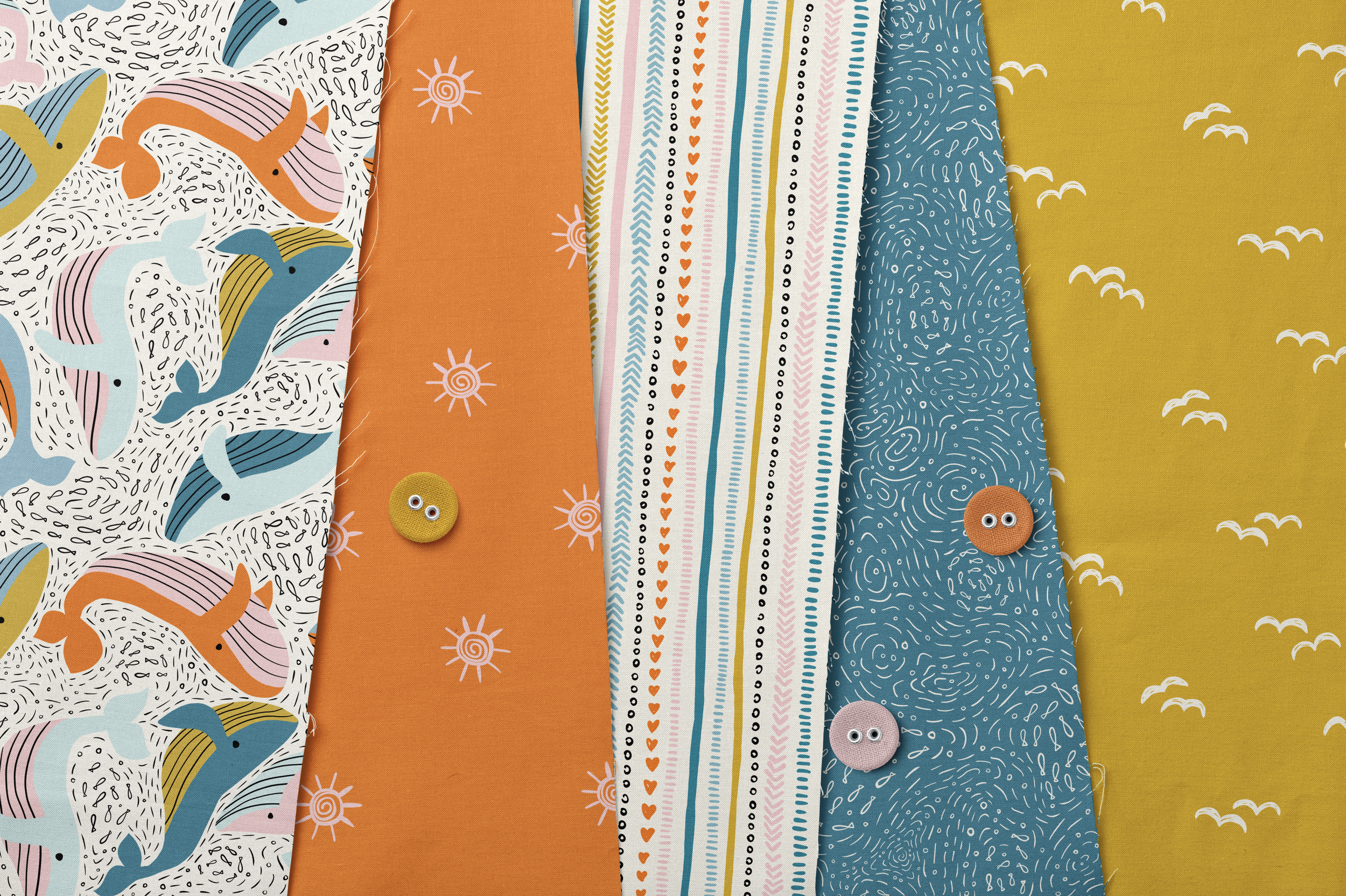Fanned fabric swatches featuring the patterns from the Boho Whale Nursery collection