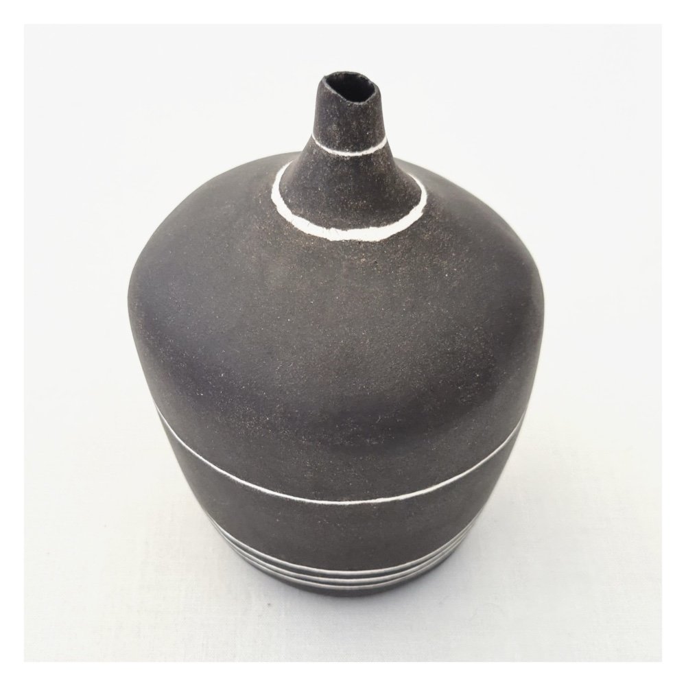 It has an uneven opening and the surface has been left unglazed giving it a matt finish.
