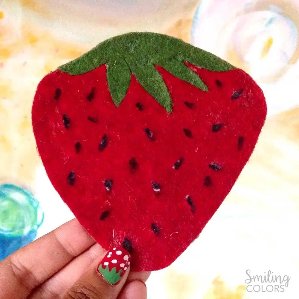 strawberry DIy felt coaster hold in fingers