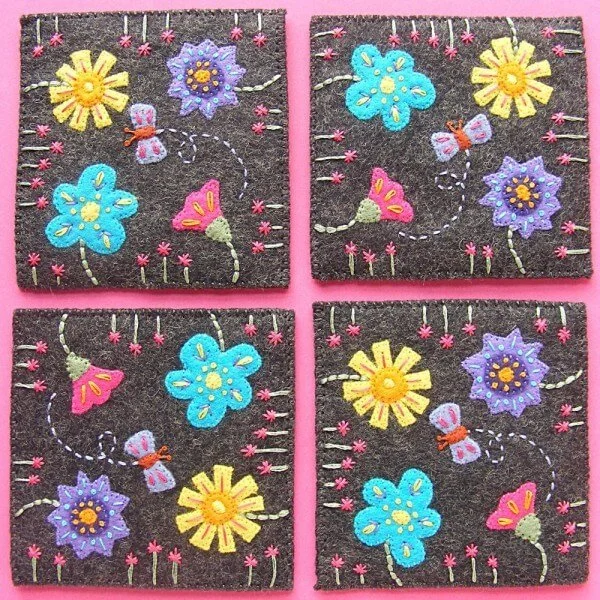 four flowery felt coasters with black background