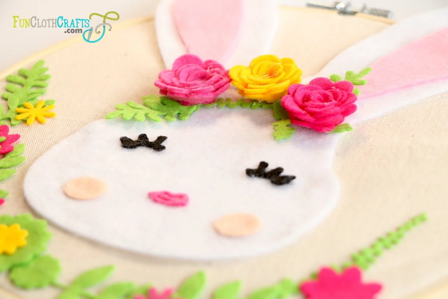 DIY felt bunny wall decor detail of white felt bunny face with closed dreamy eyes and felt flowers