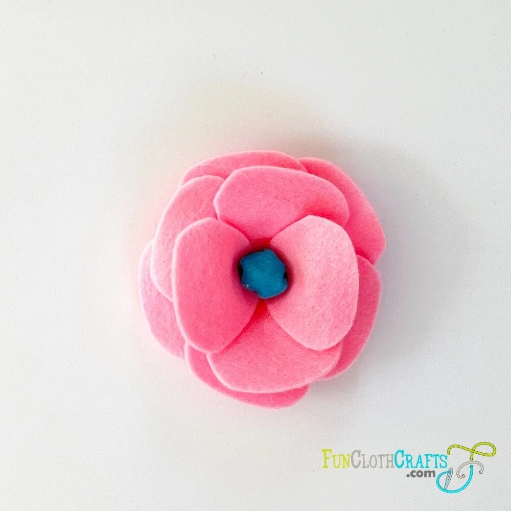 petal by petal felt flower, blue center piece and eight pink felt petals that make the felt flower