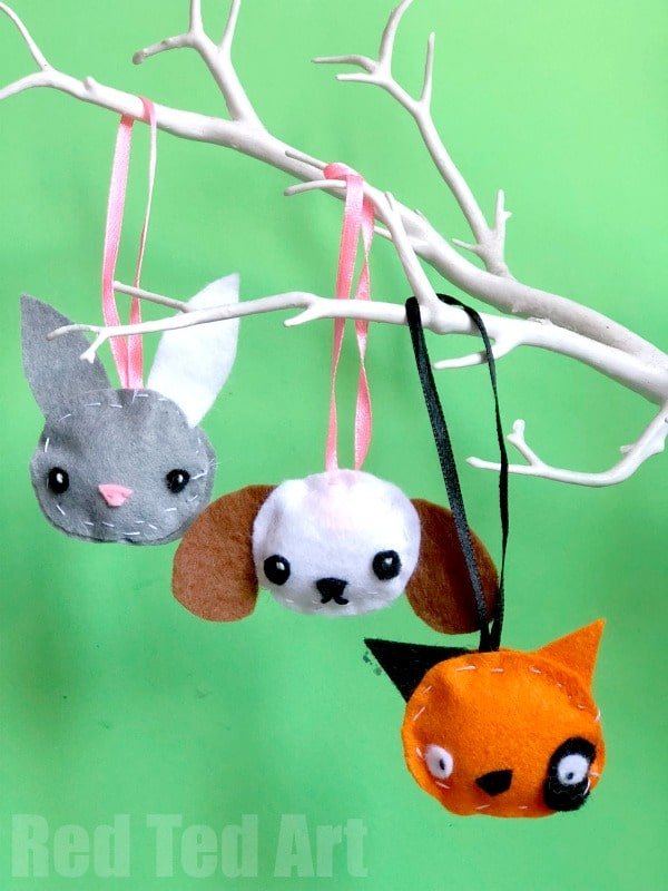 mini felt animal ornaments from felt scraps hanging on a branch