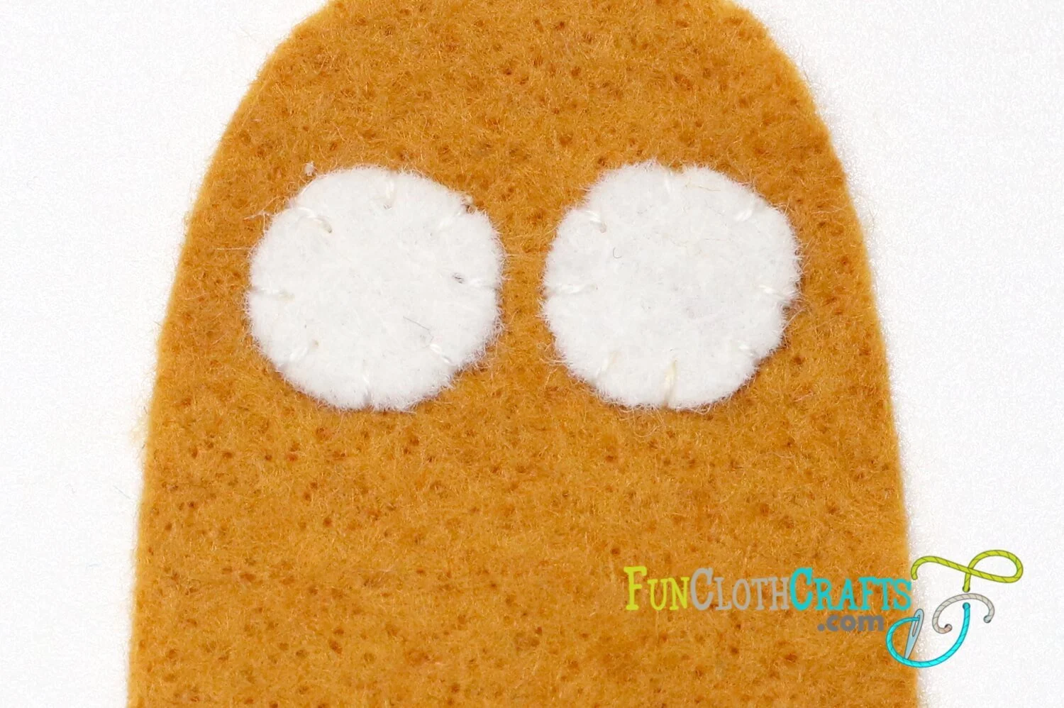 two white circles embroidered to felt with whip stitch to make eyes