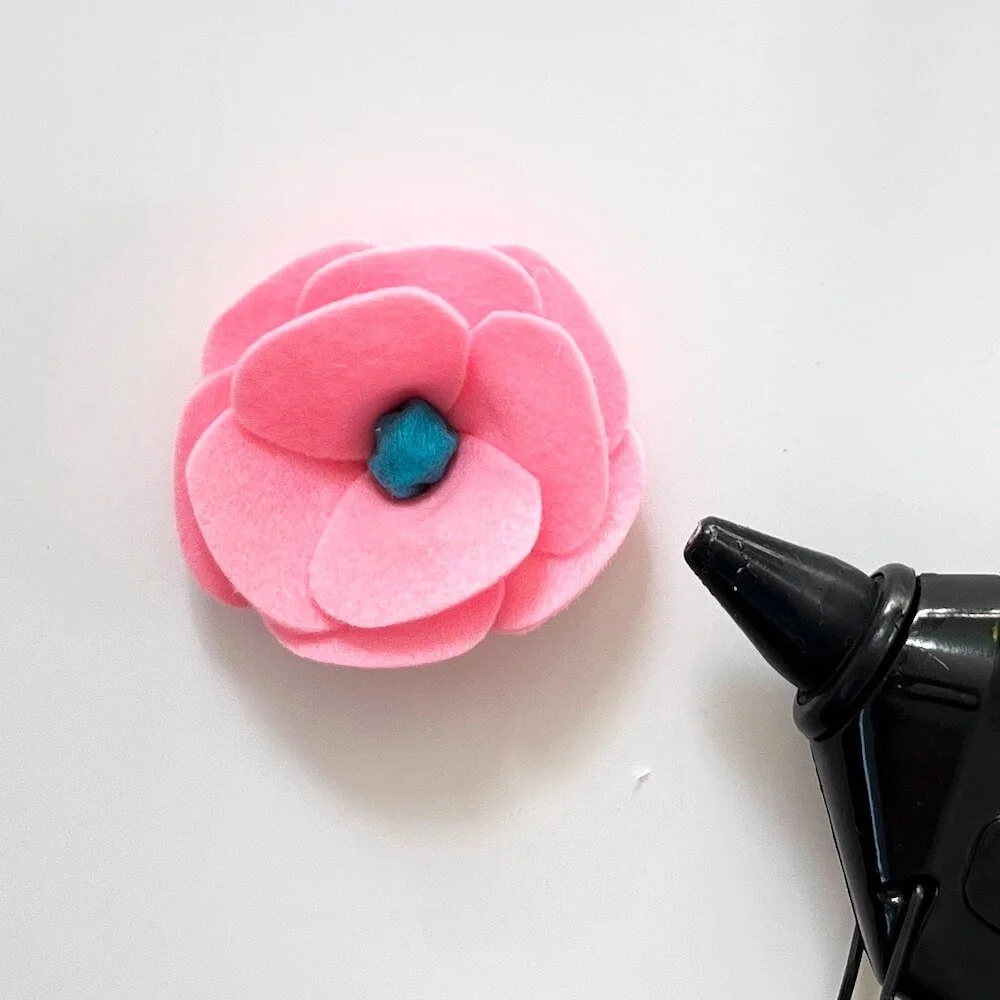 petal by petal felt flowers step 5, hot glue gun and eight felt petals attached to the felt flower