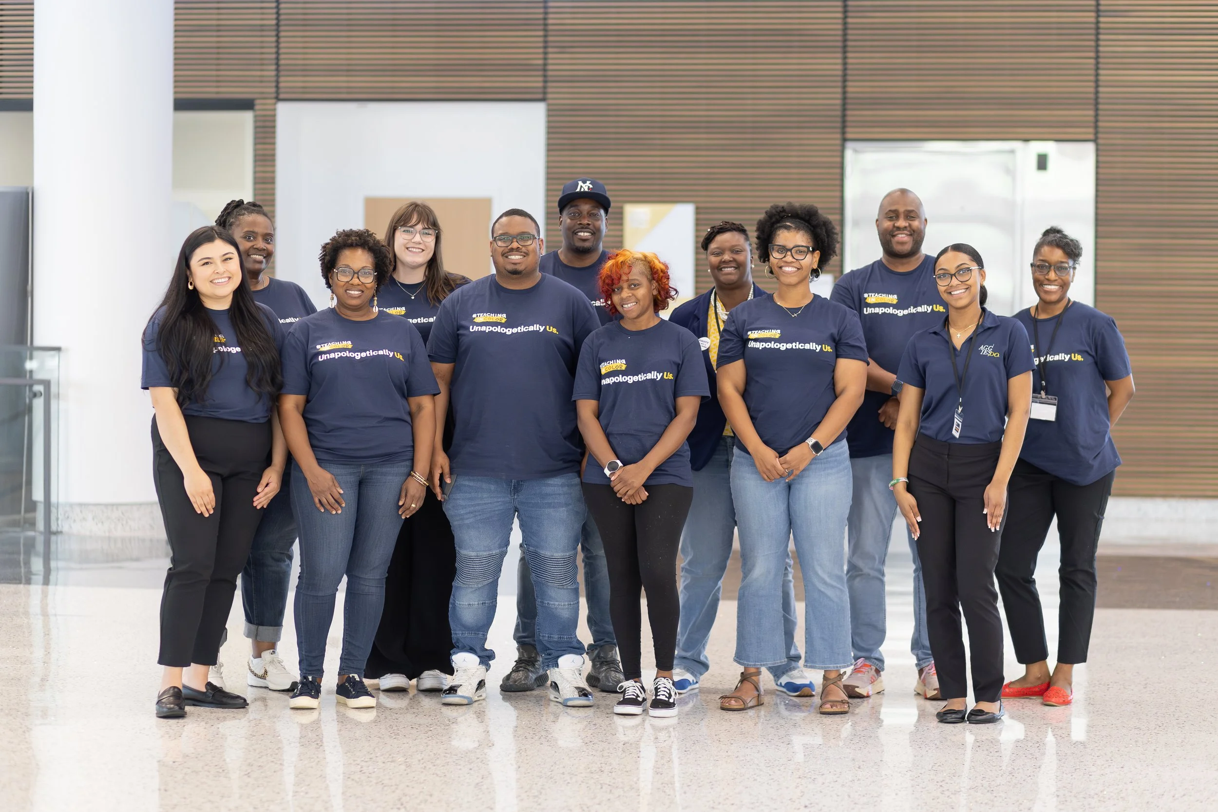 A group of people in matching blue shirts smiling for a photograph