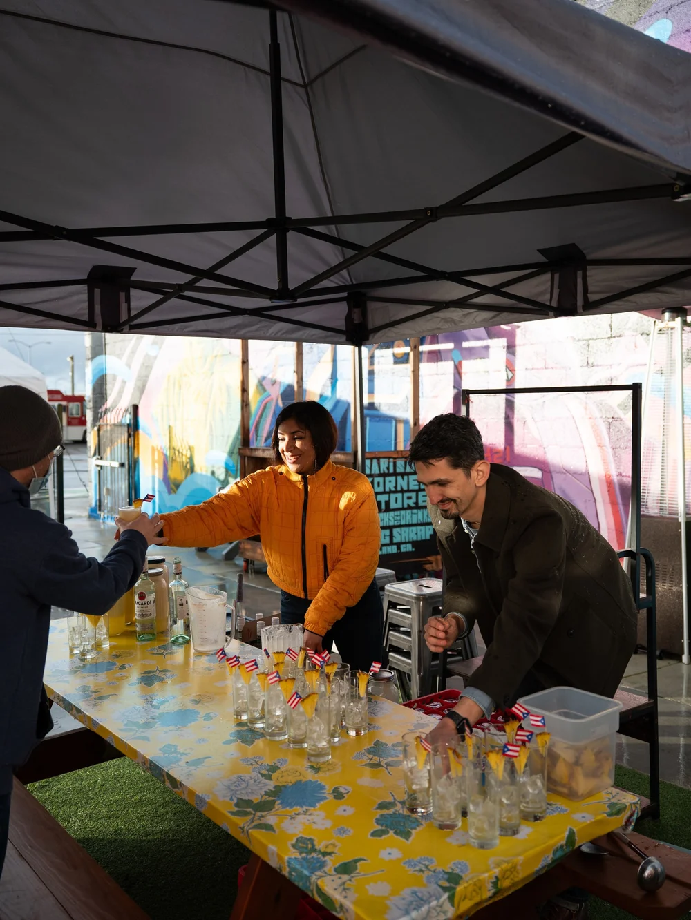 Volunteers serving drinks under a tent at a Slow Food East Bay event