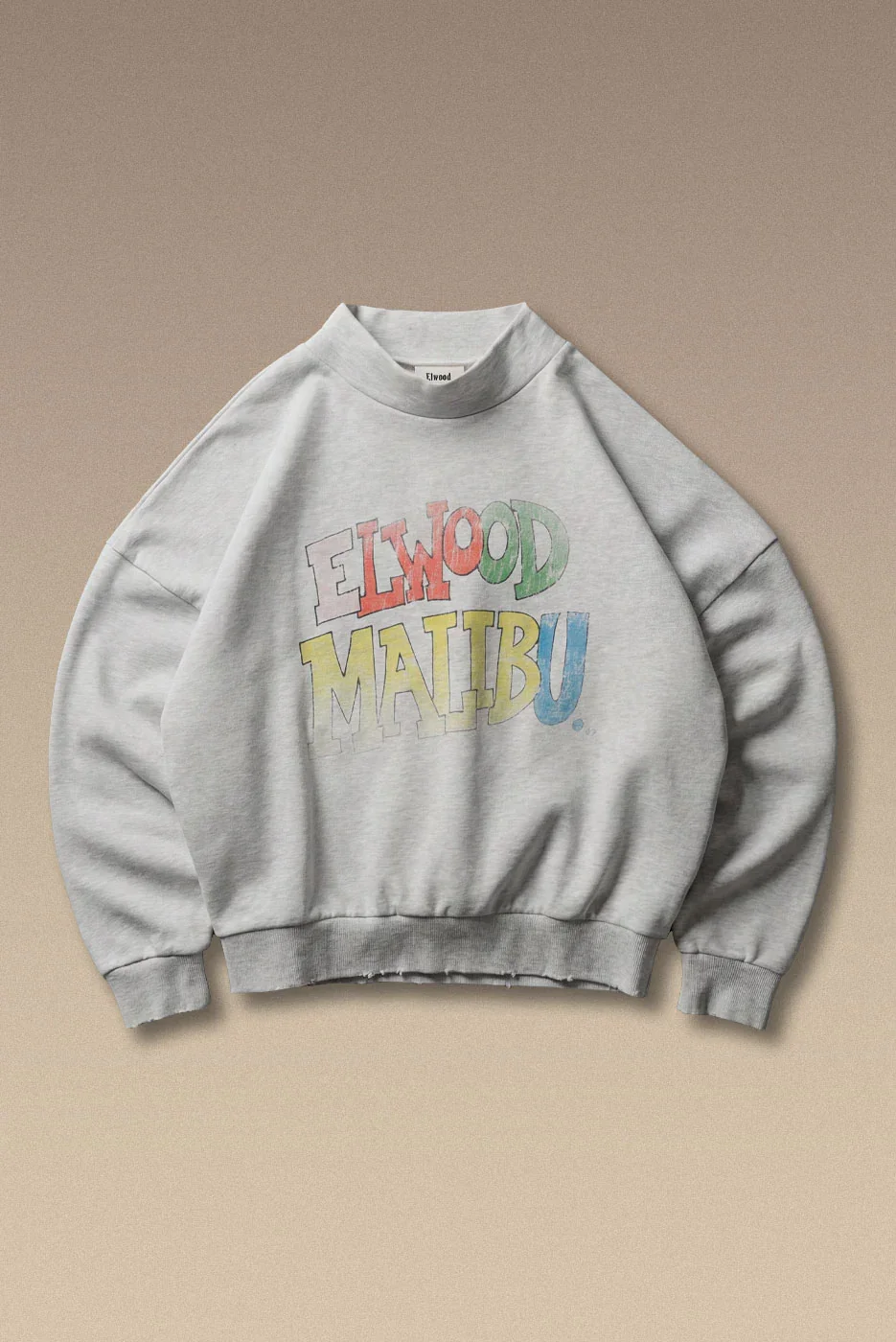 A heavyweight French terry crew with a wide mock neck in hazy heather grey. Features a colorful Elwood Malibu graphic, with light distressing at the hem and cuffs.