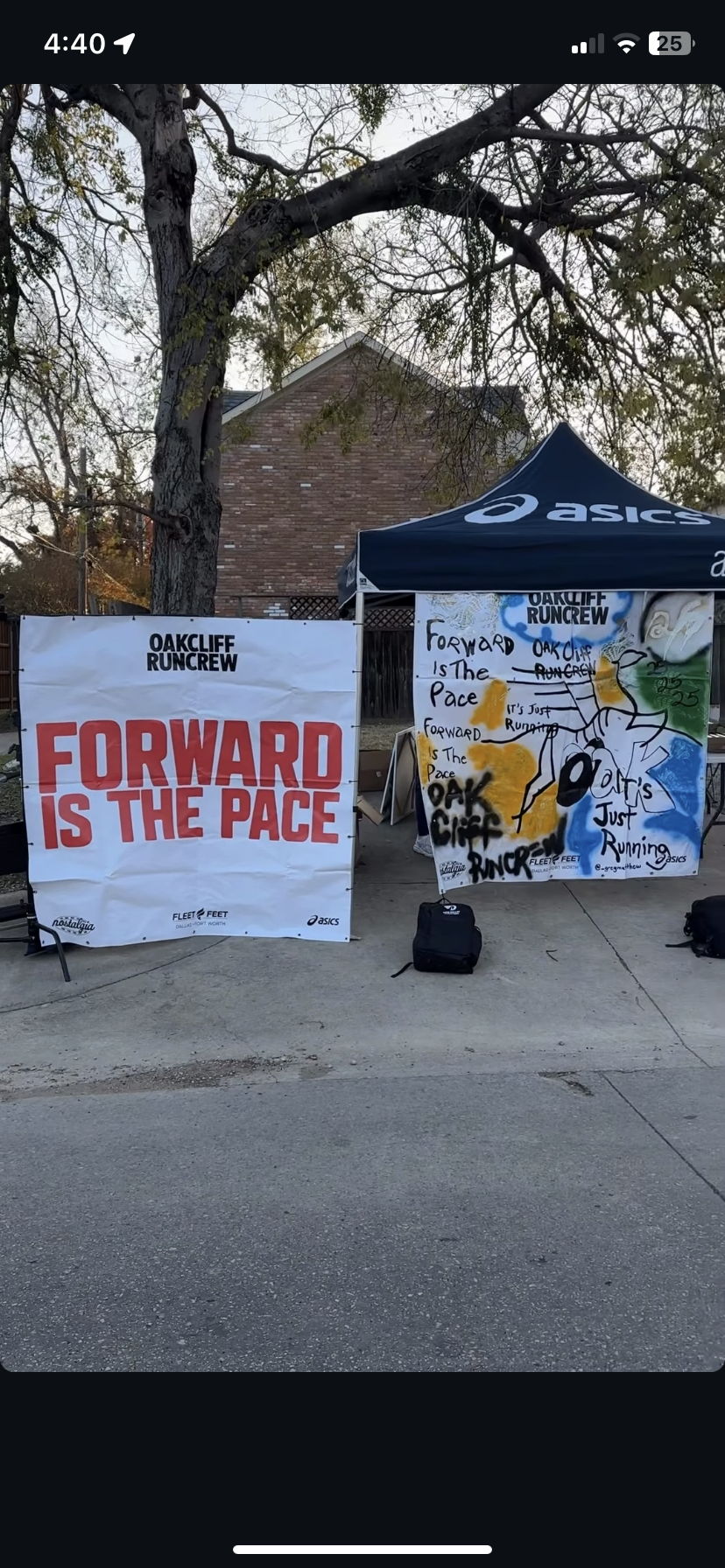 Outdoor setup with two banners and a canopy tent promoting Oakcliff Runcrews. One banner reads "Forward is the Pace" in red letters, and the other has handwritten notes and artwork.