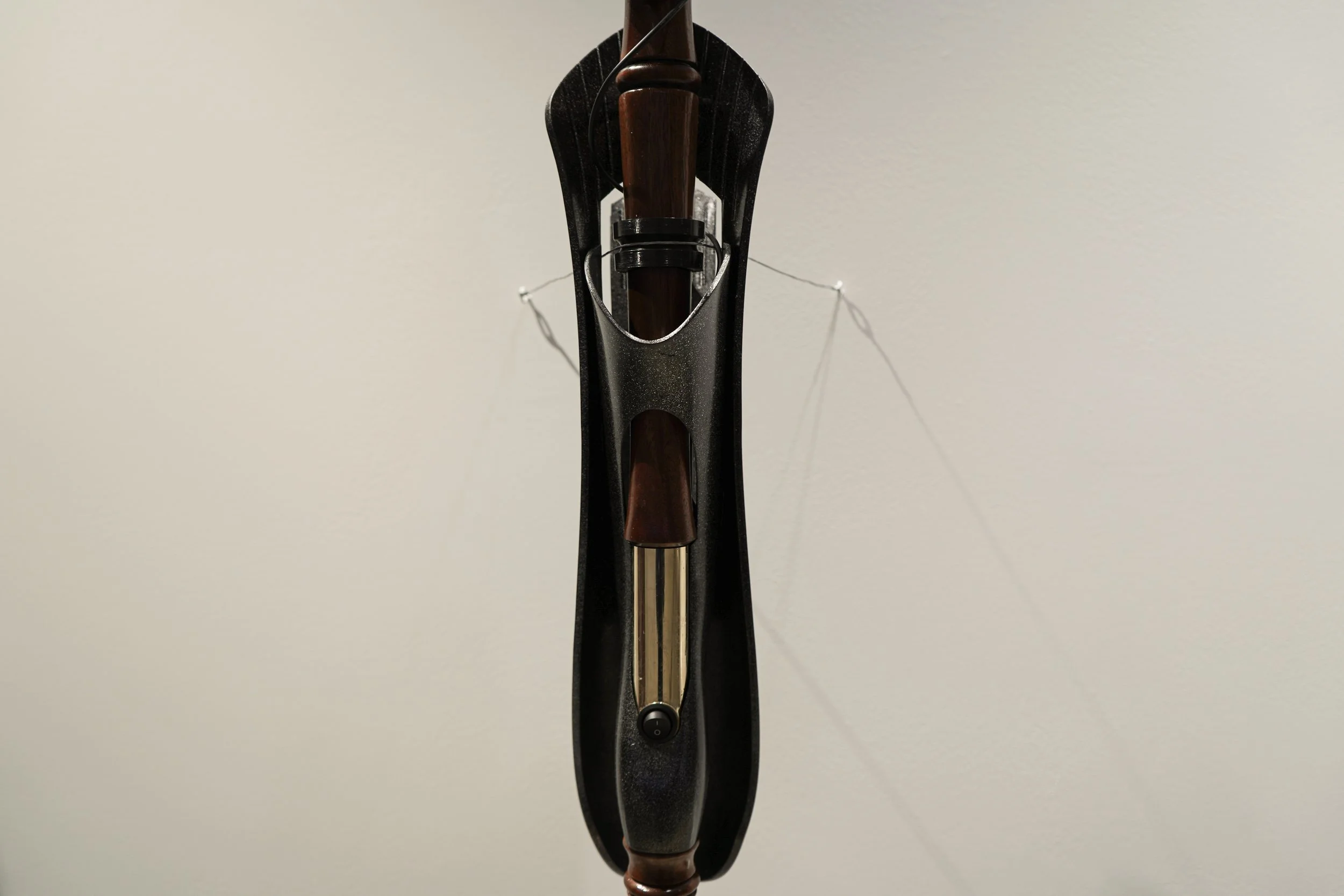 Close up of student's walking stick in metal, black, mahogany wood, and gold accent