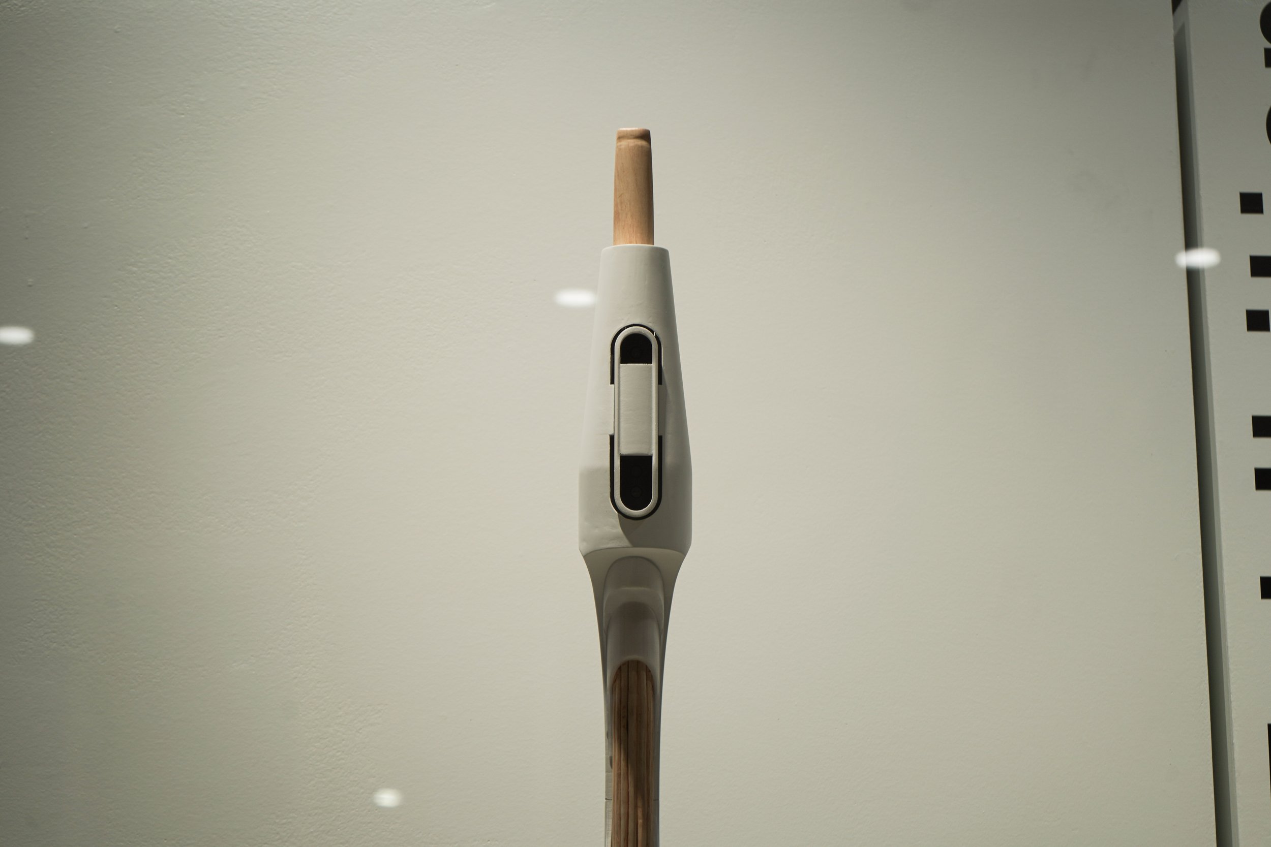 Close up of student's walking stick. Light wood staff with white top