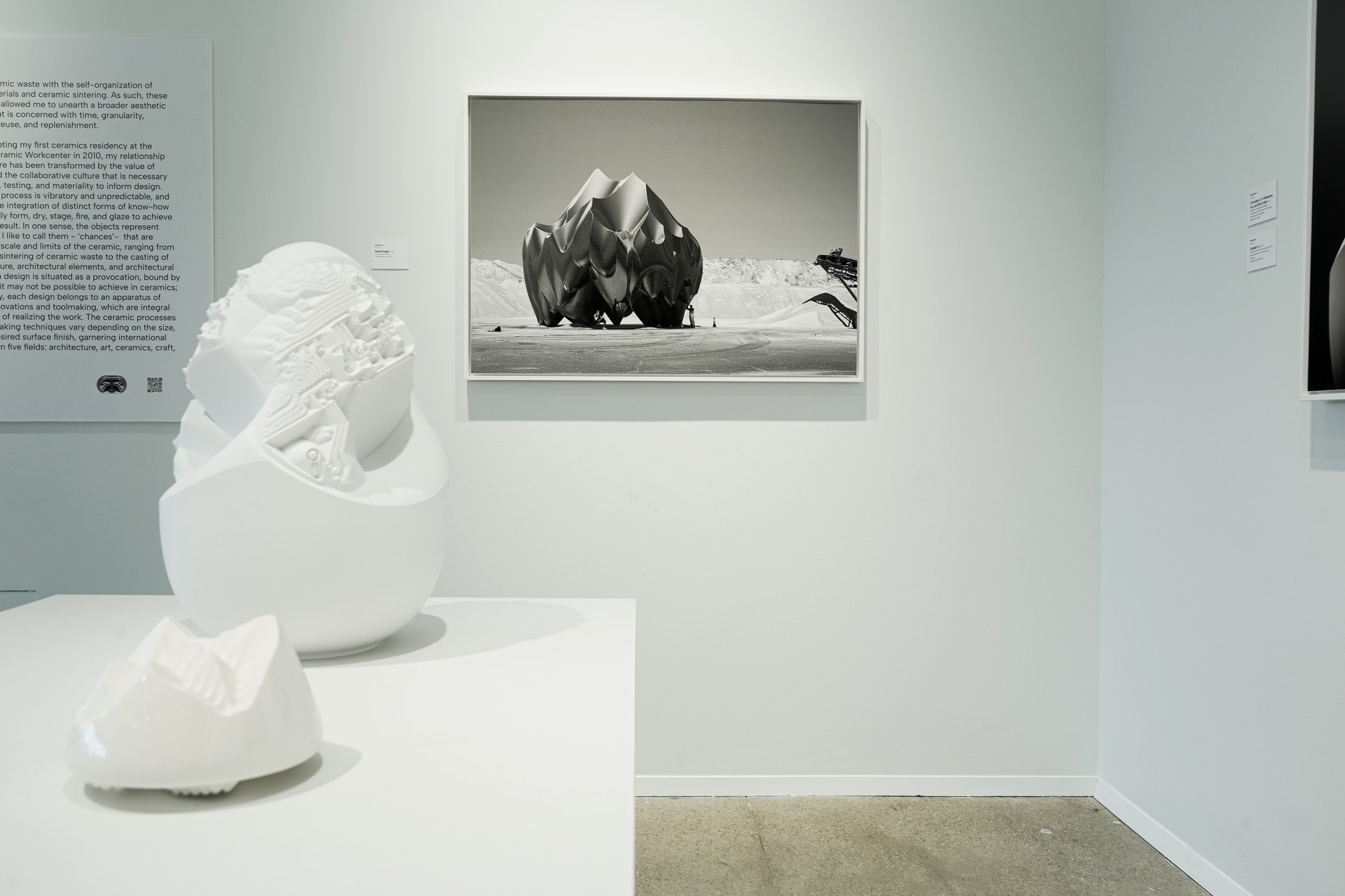 Ceramicology exhibit showing white sculpture with black and white print on the wall in the background