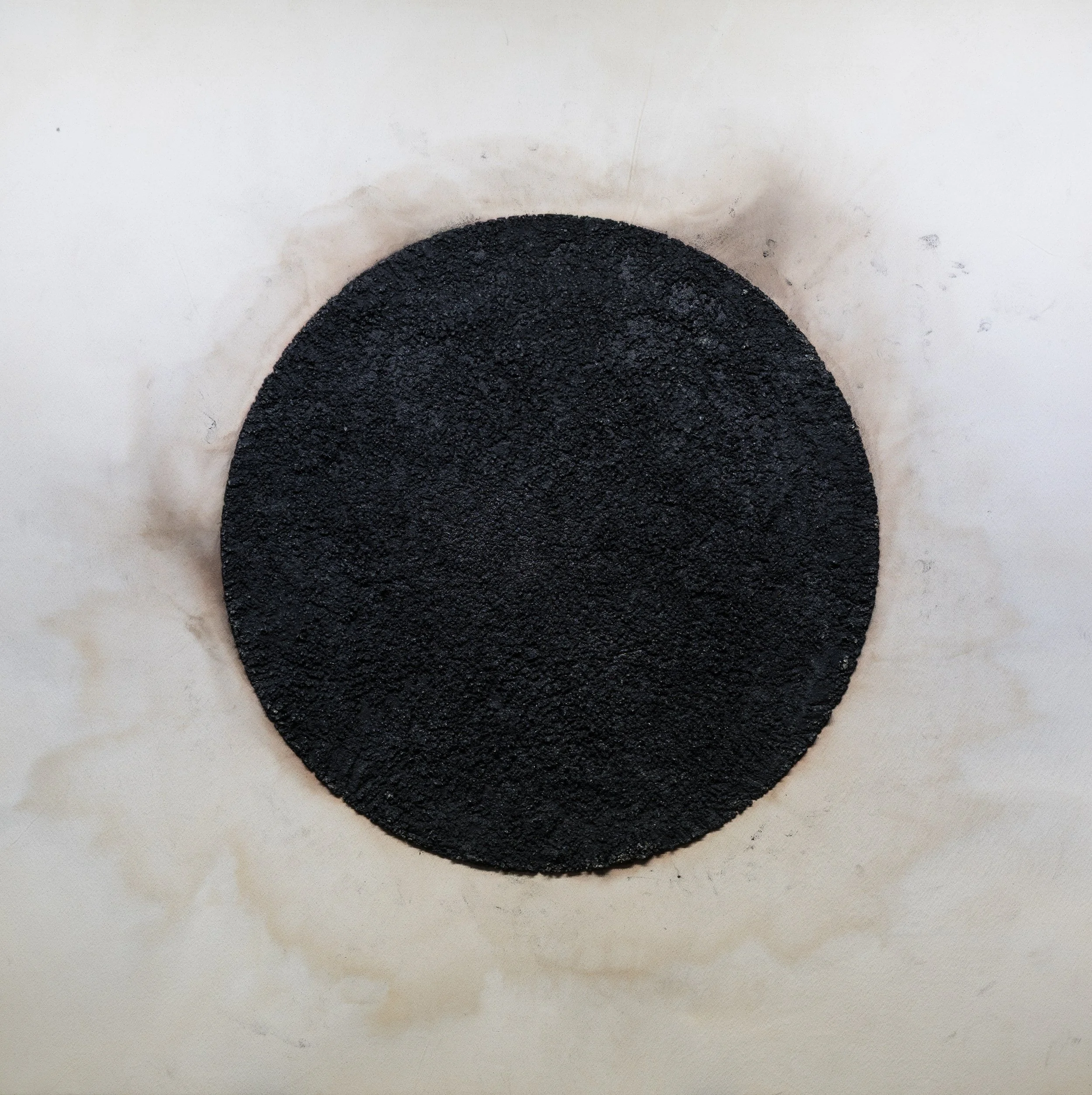 Black granular circle on a white background