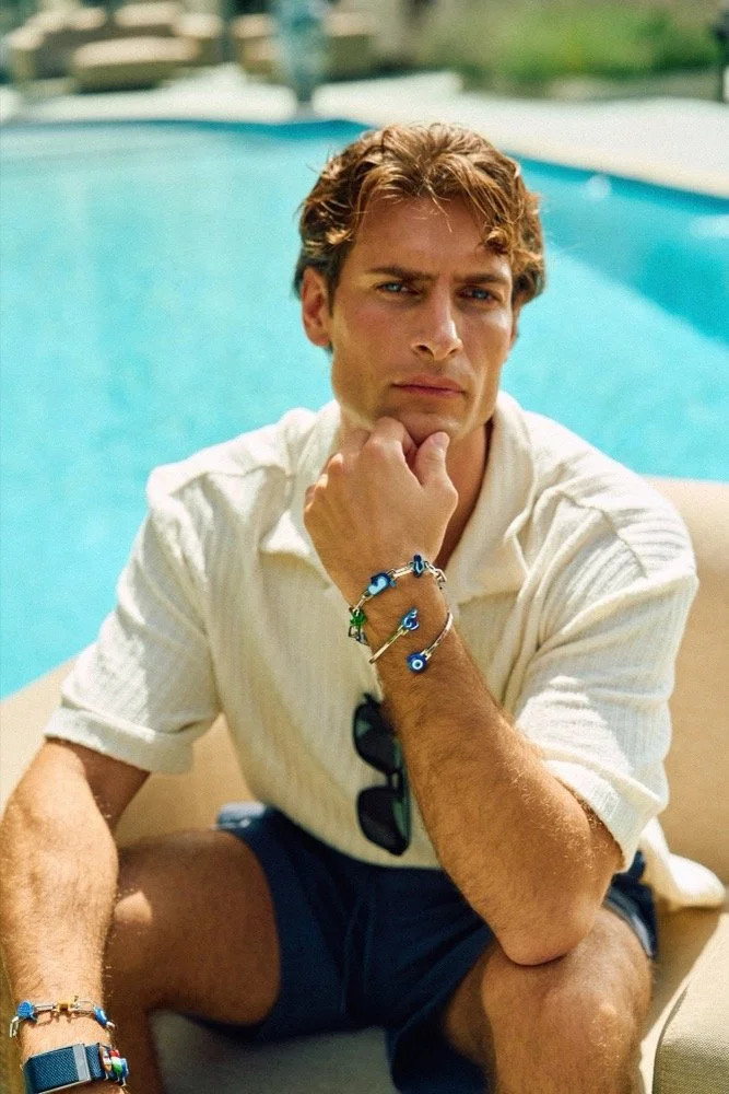 Man sitting by the pool while showing off his Modular Jewellery designed by Poubel
