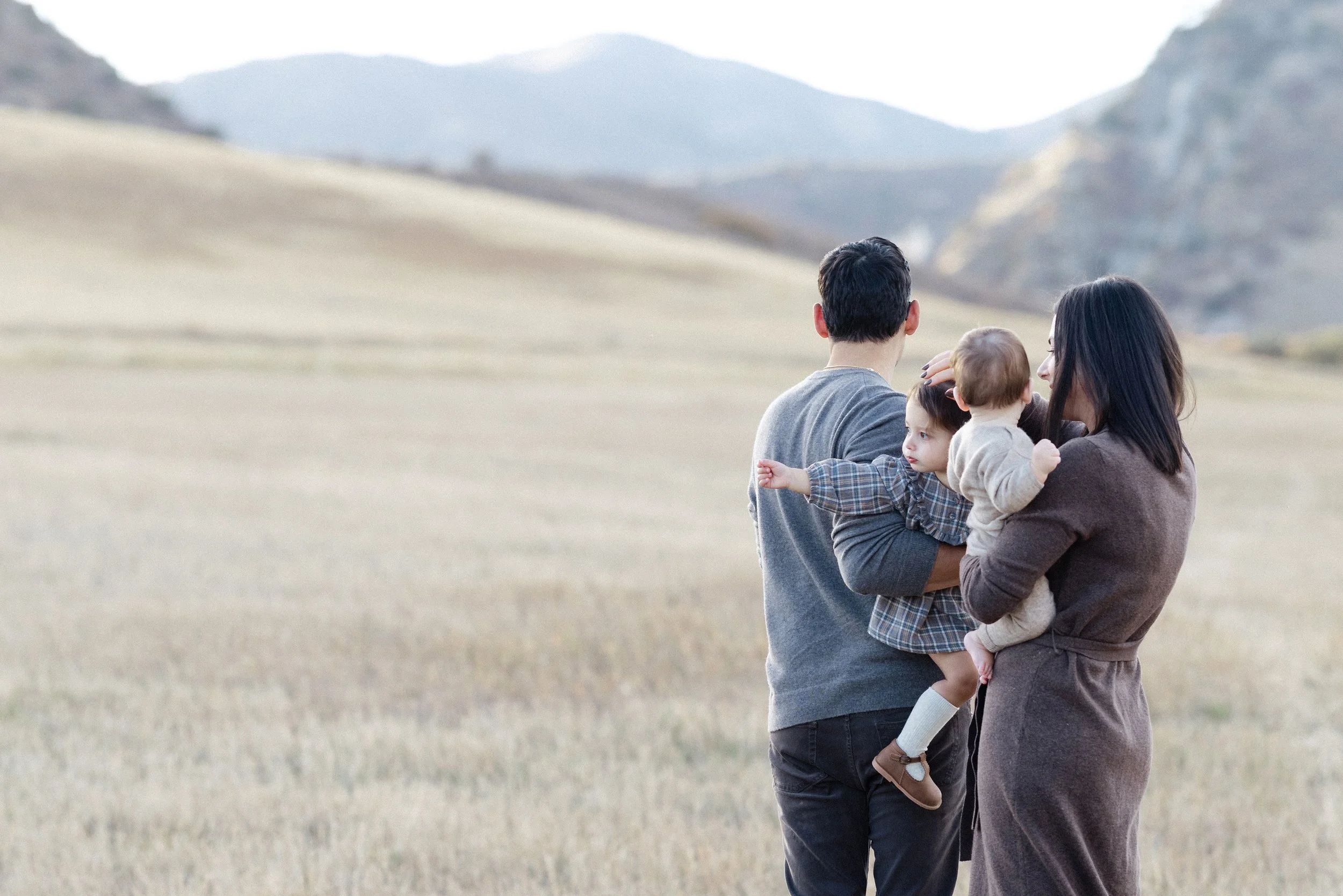 Family gathered together overlooking the open landscape and Colorado foothills.