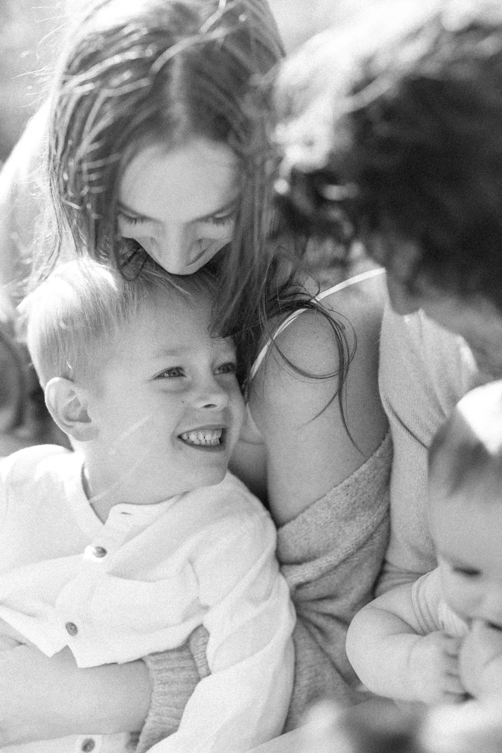 Black-and-white close-up of a mother with her young children during a family portrait session.