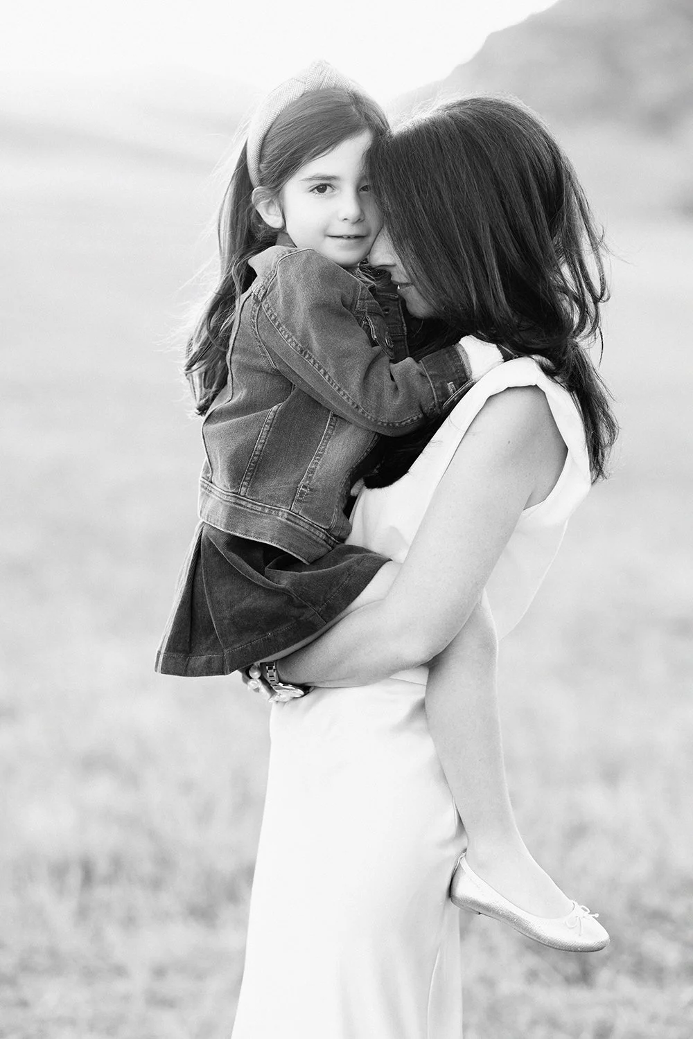Mother and young daughter sharing intimate moment during family portrait session