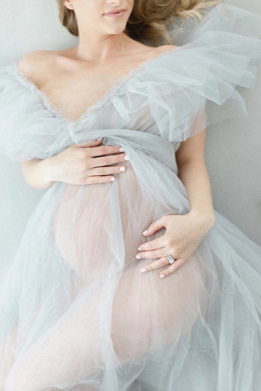 pregnancy photo of woman in pale blue tulle gown
