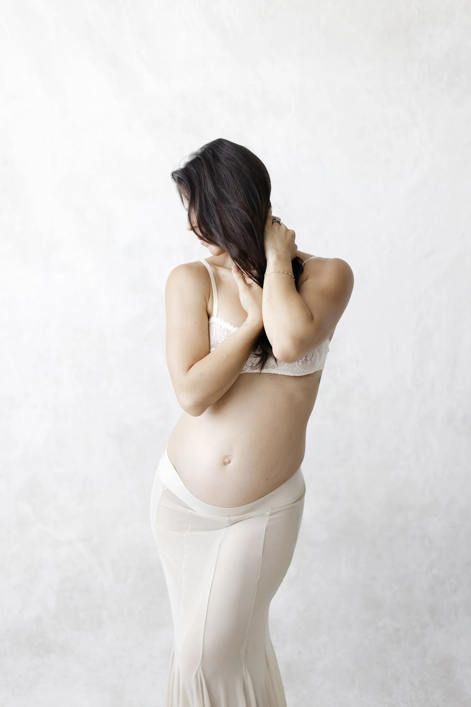 pregnant woman in bra and sheer skirt