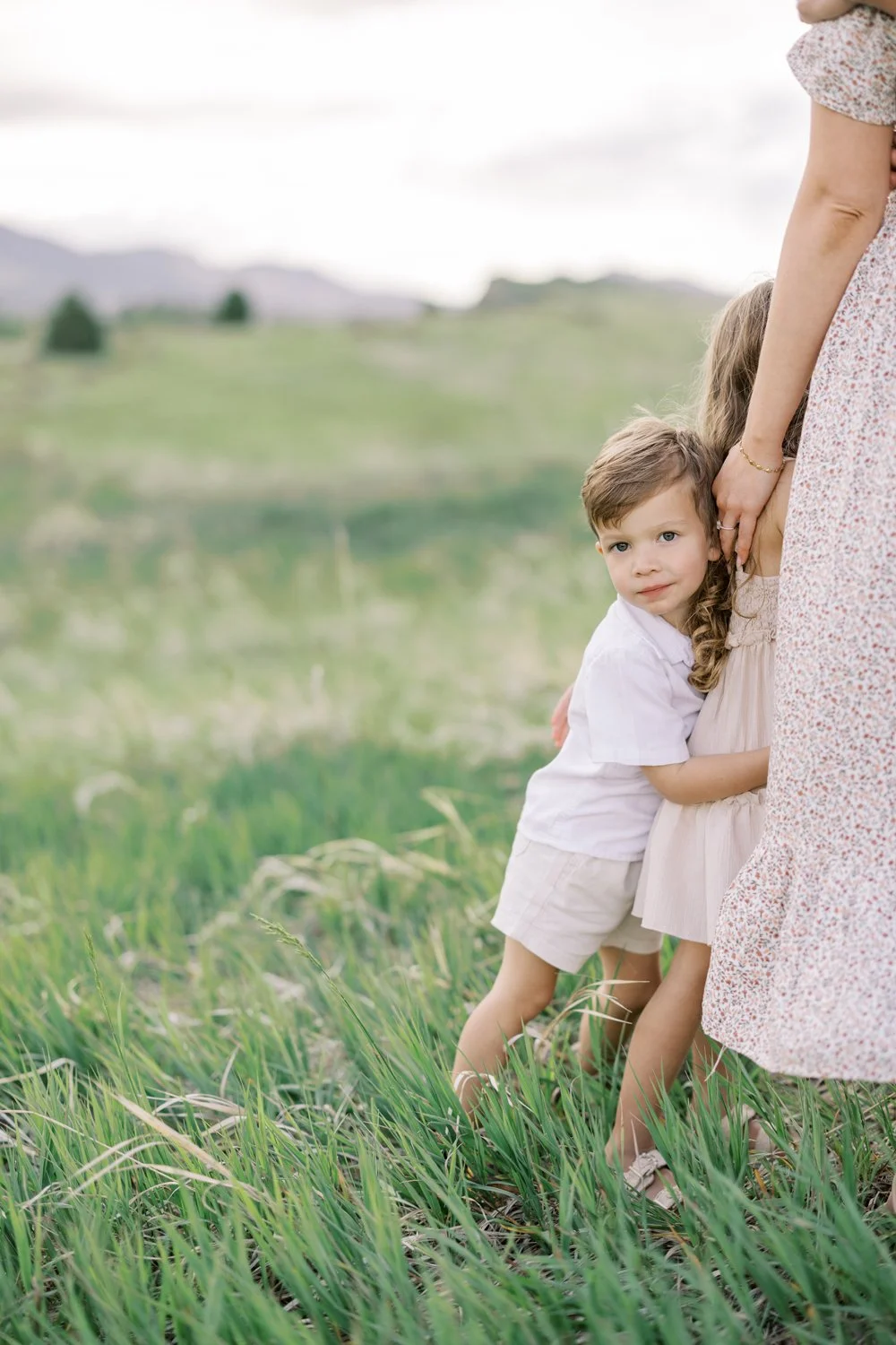 Son snuggling into family portrait in a Colorado open field.