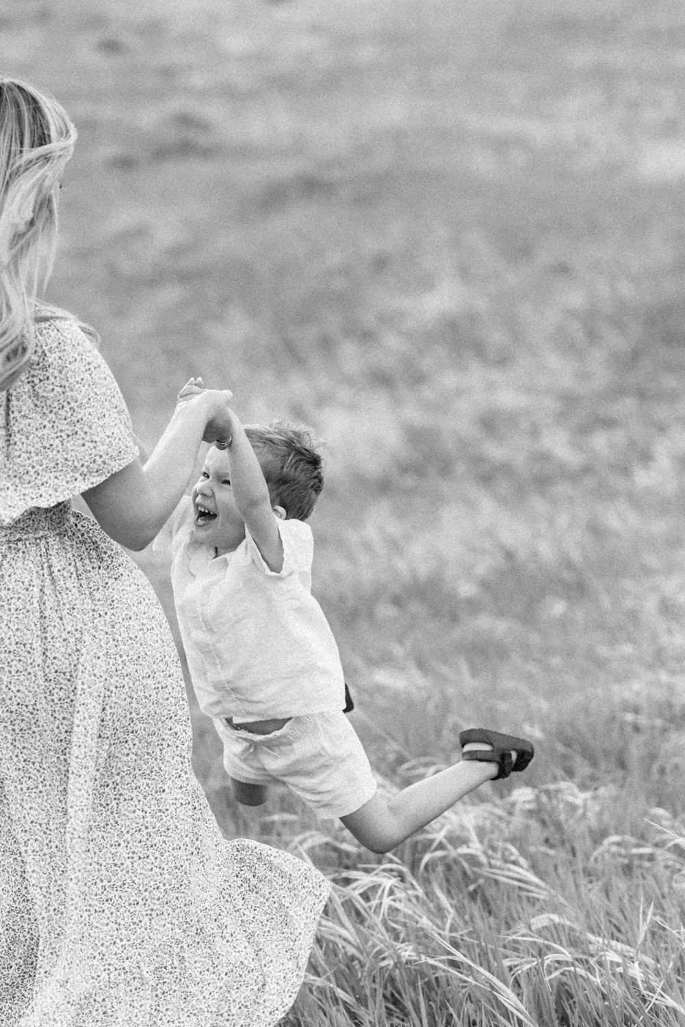 Mother swinging son in playful family portrait