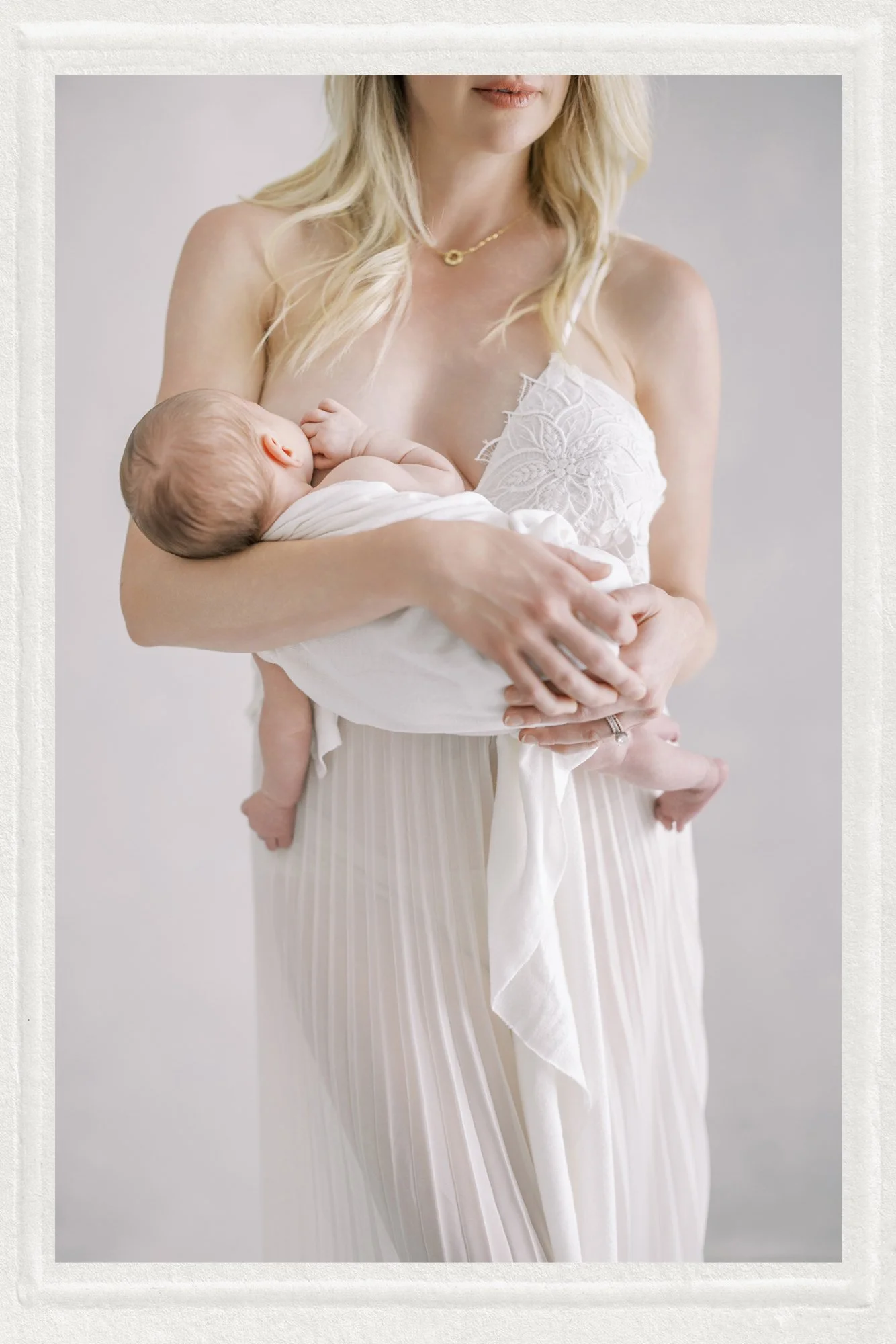matted photo of mother cradling baby in minimalist portrait