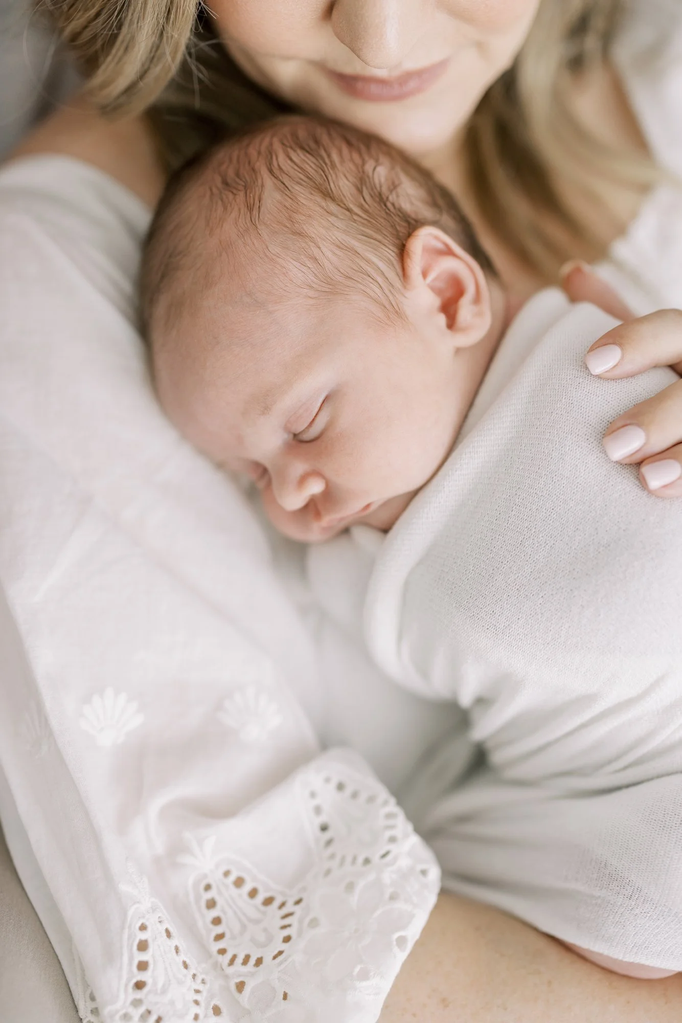 Sleeping newborn resting peacefully on their mother's chest during a studio newborn photography session.