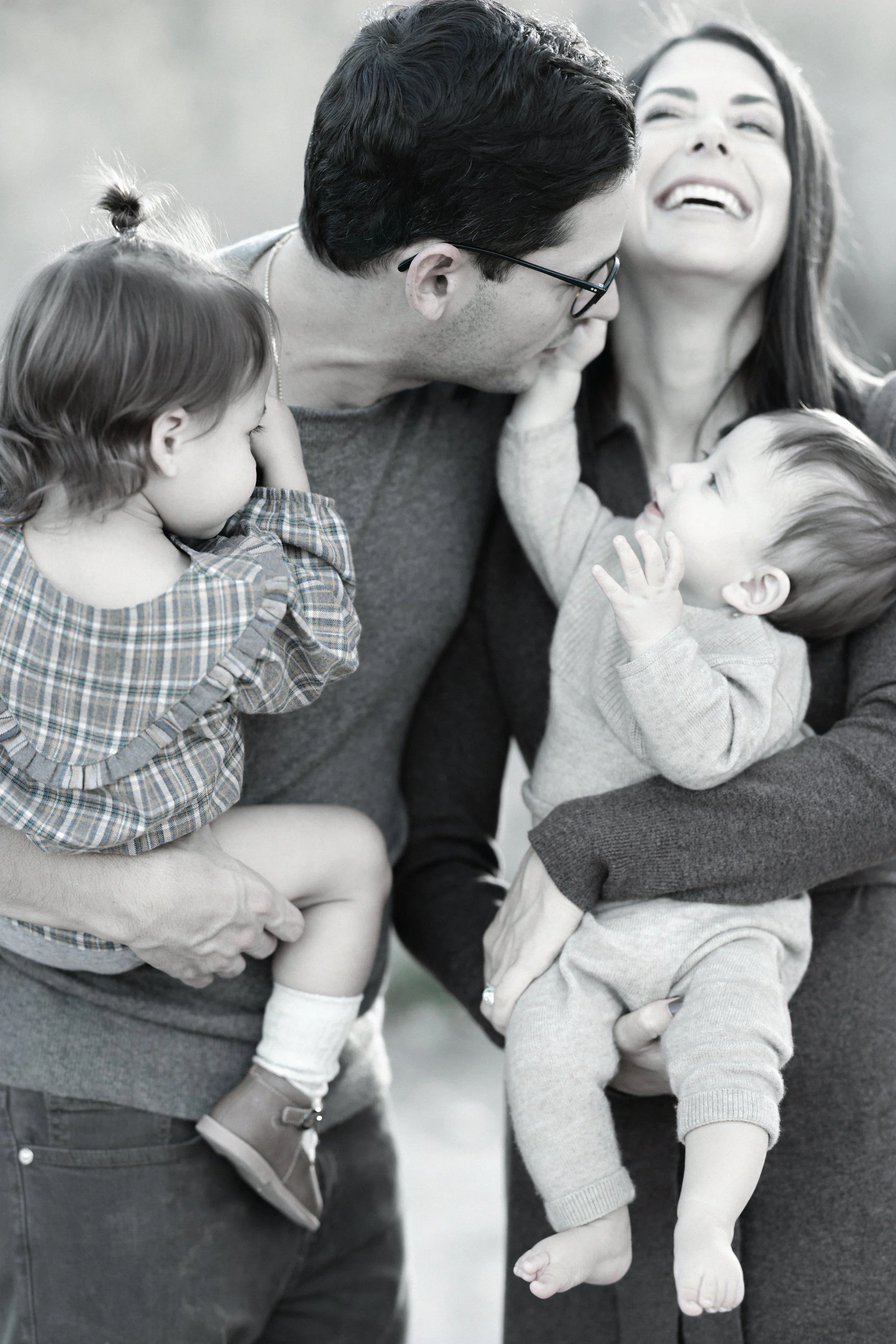 Family laughing together during a candid outdoor portrait session in Denver, Colorado.