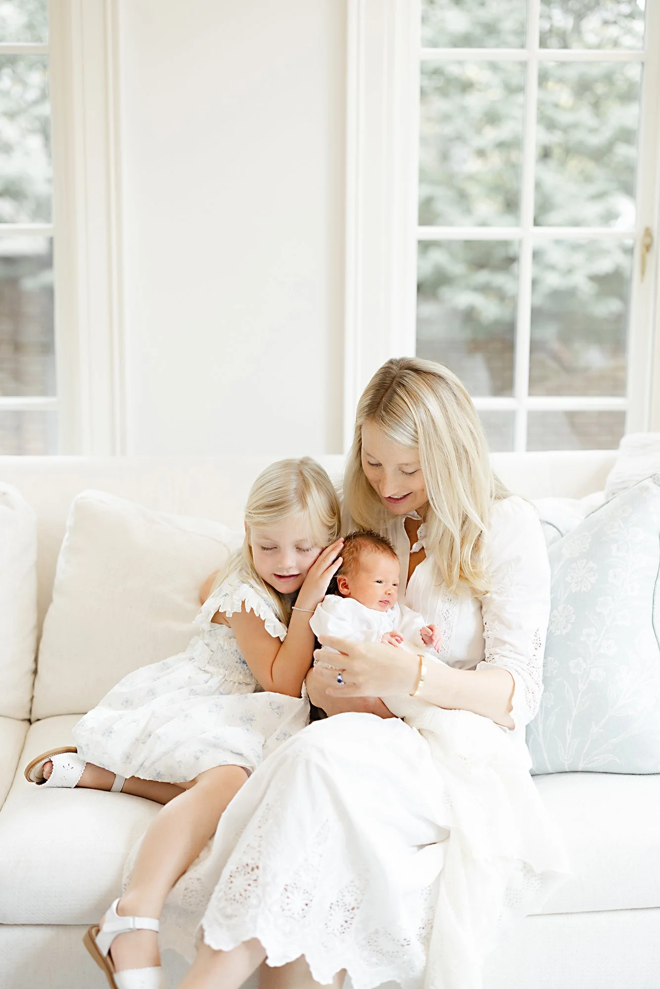 Family spending time together in a bright living room during an in-home newborn photography session.