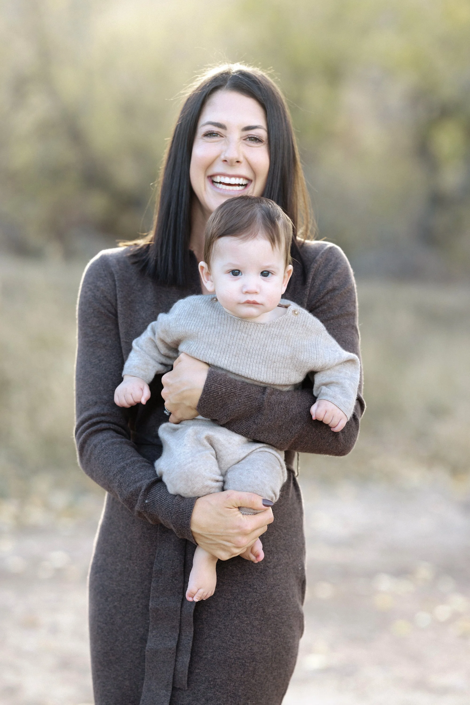 Mother holding her baby outdoors during a Colorado family portrait session.