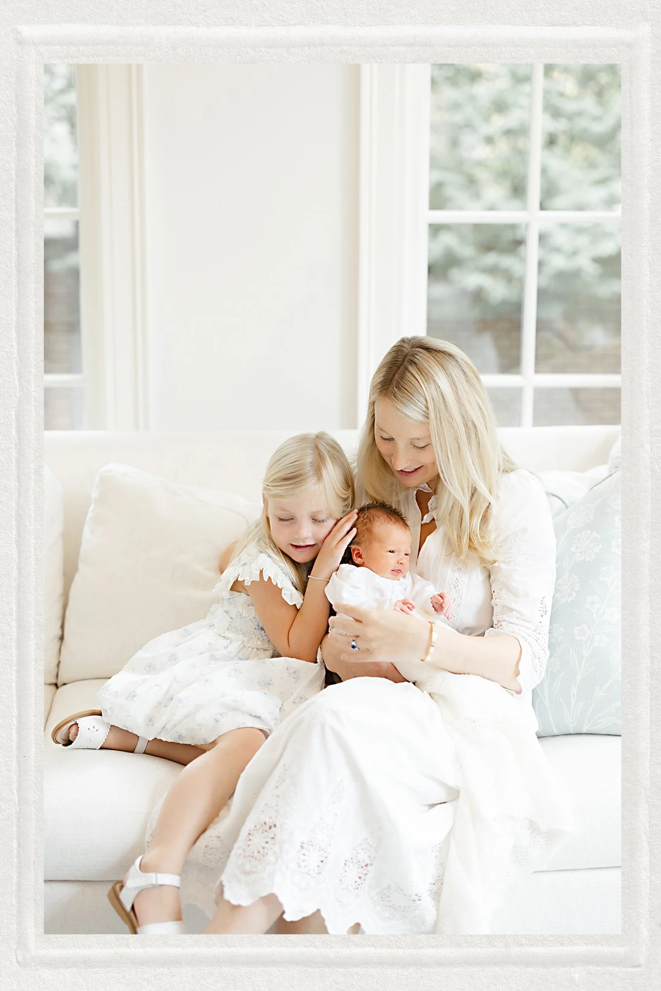Family spending time together in a bright living room during an in-home newborn photography session.