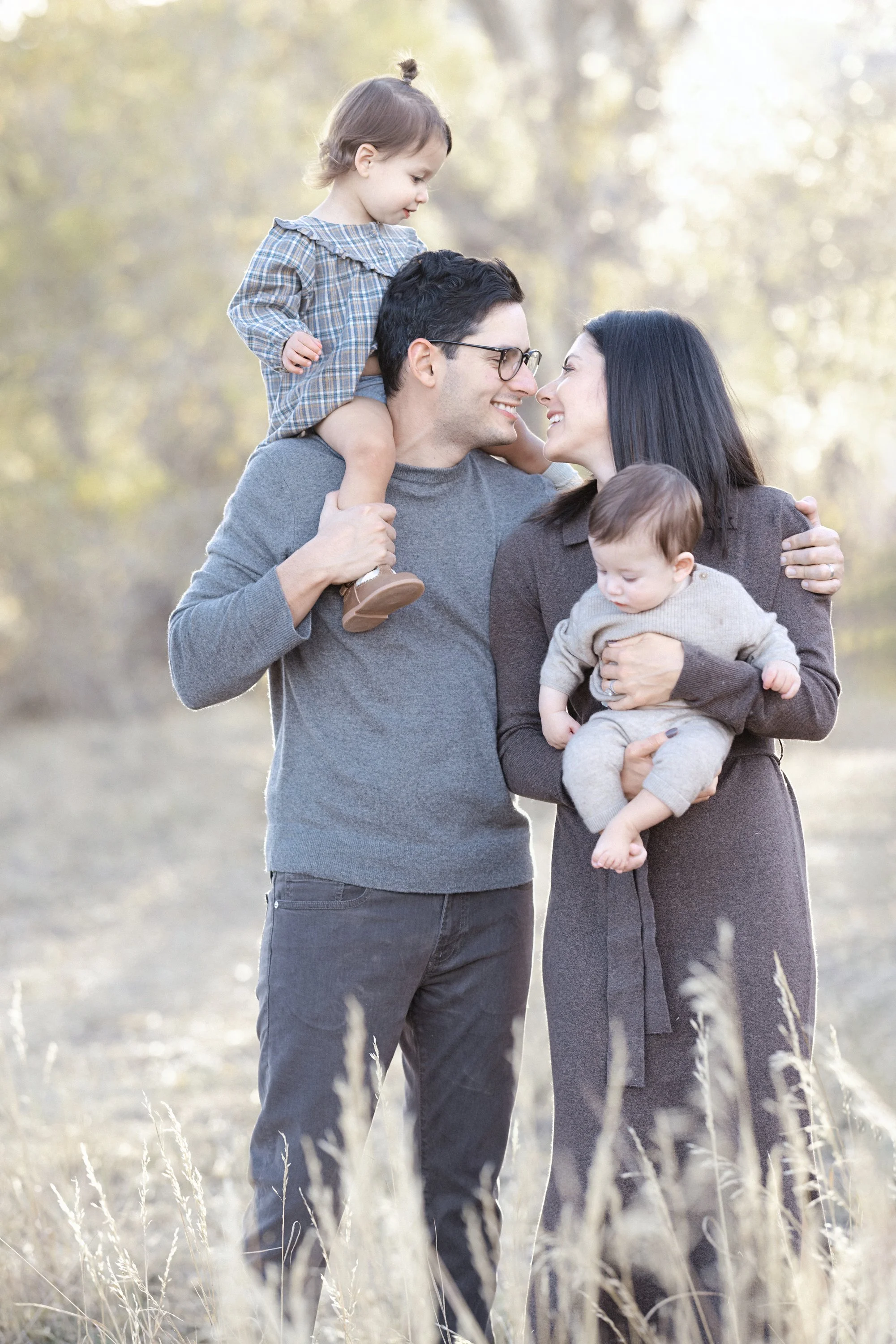 Mother and father share an intimate glance during family portrait