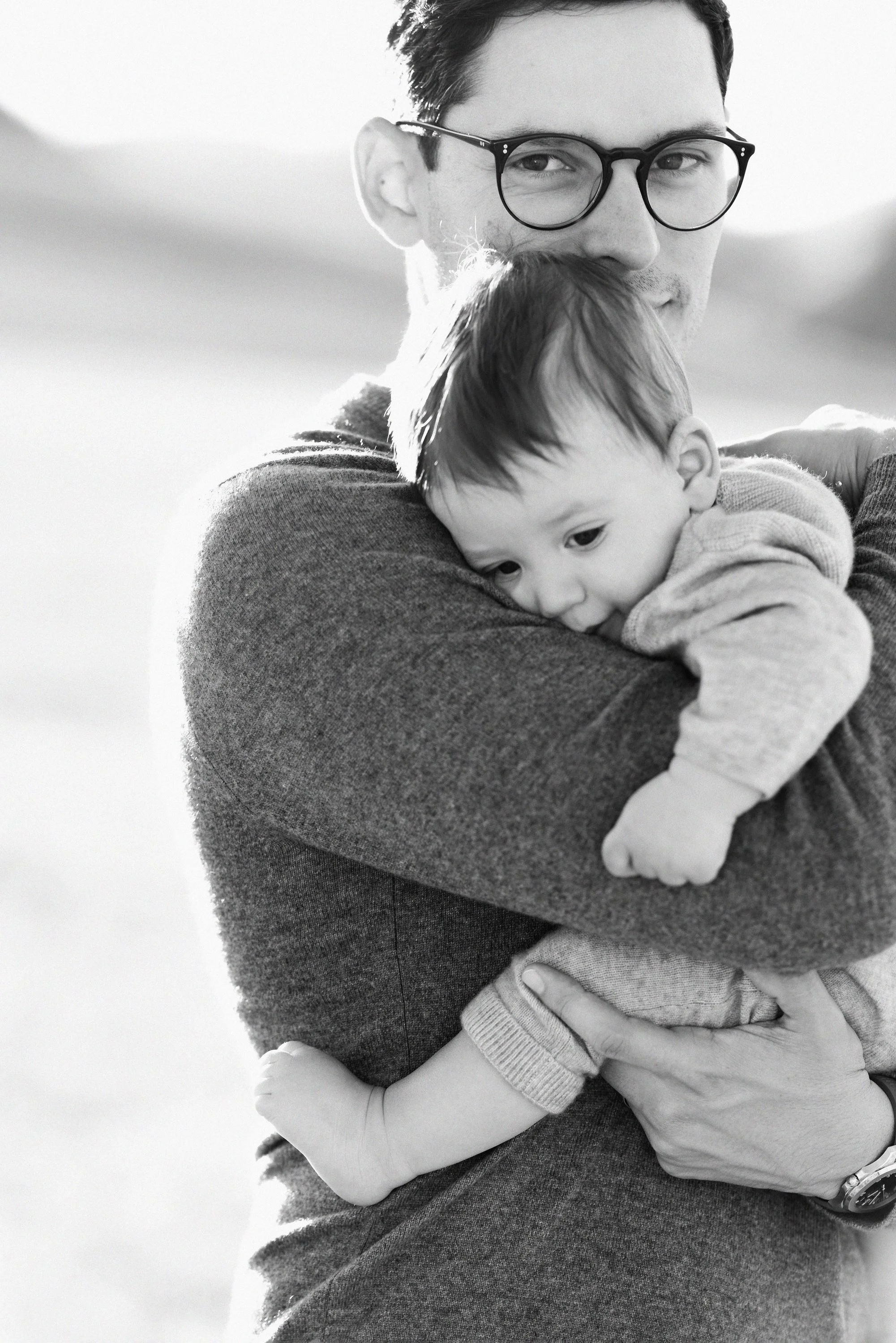 Father holding her baby outdoors during a Colorado family portrait session.