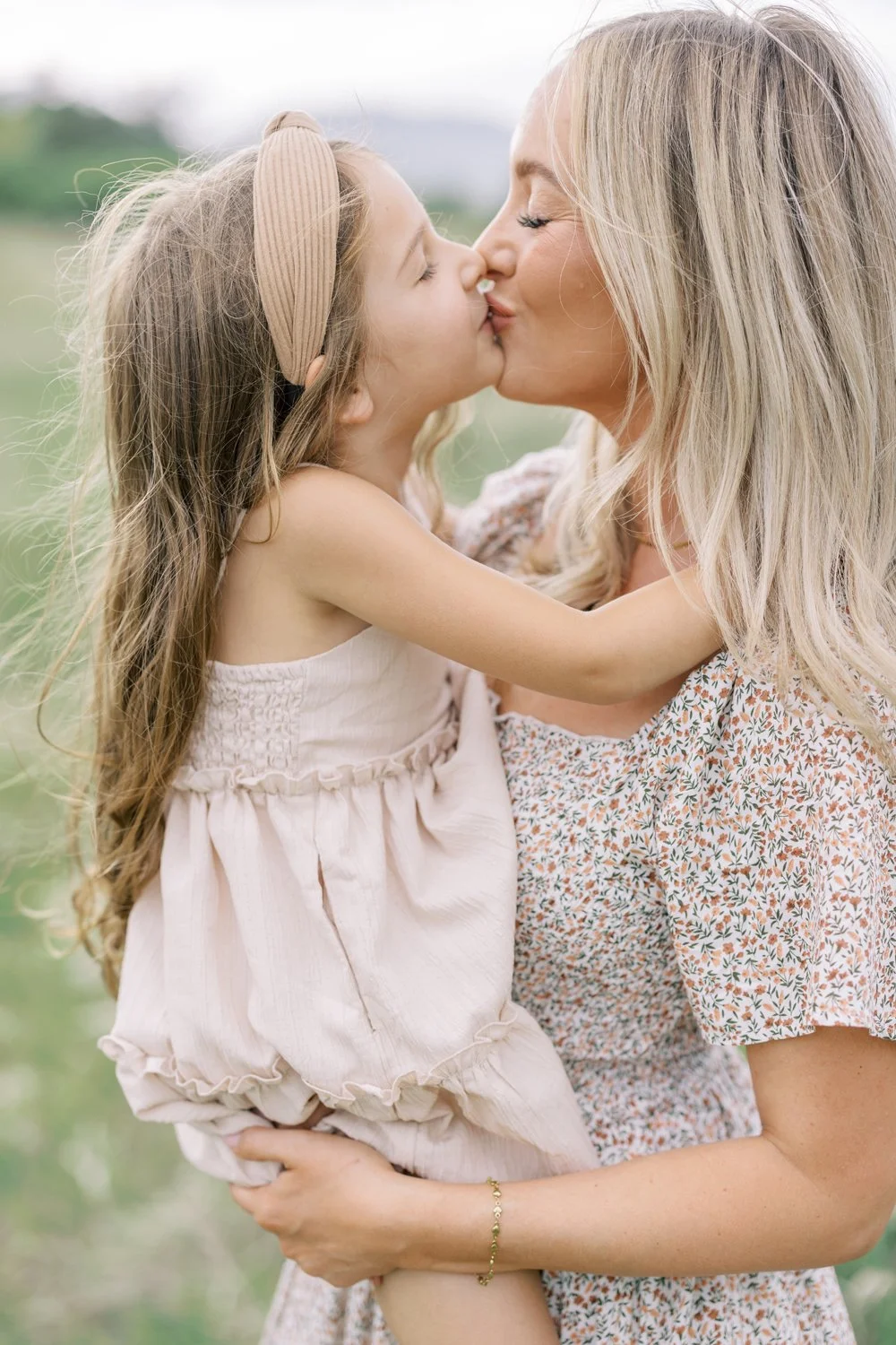 Mother daughter kissing during portrait session in Colorado hills