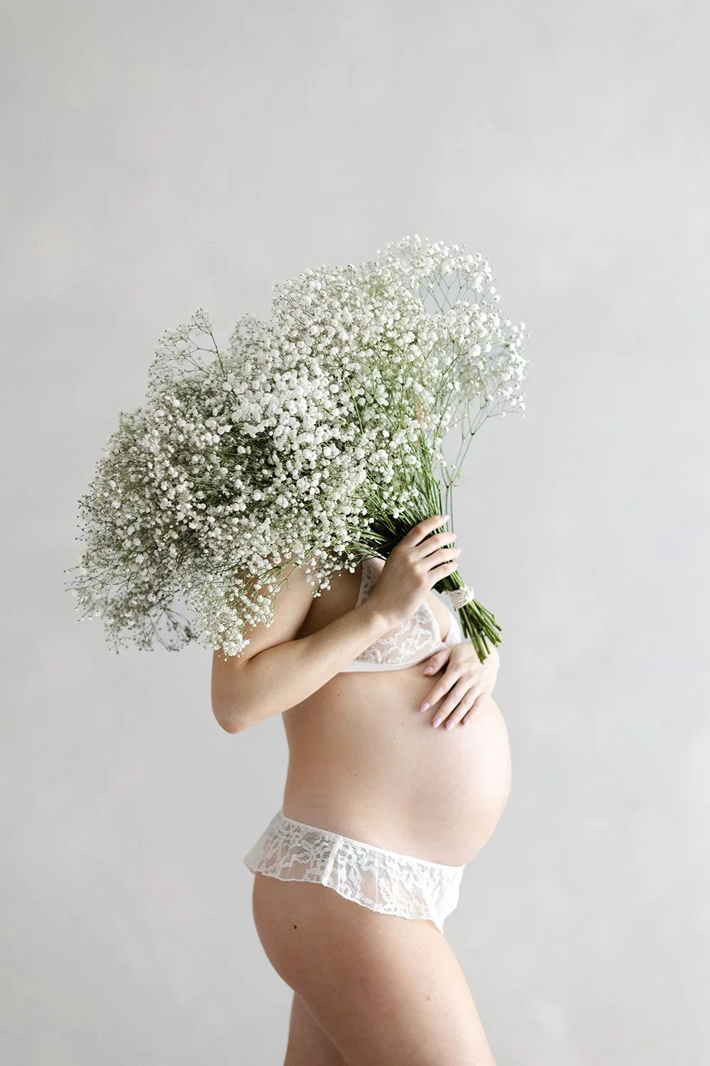 pregnant woman with artful bouquet of florals