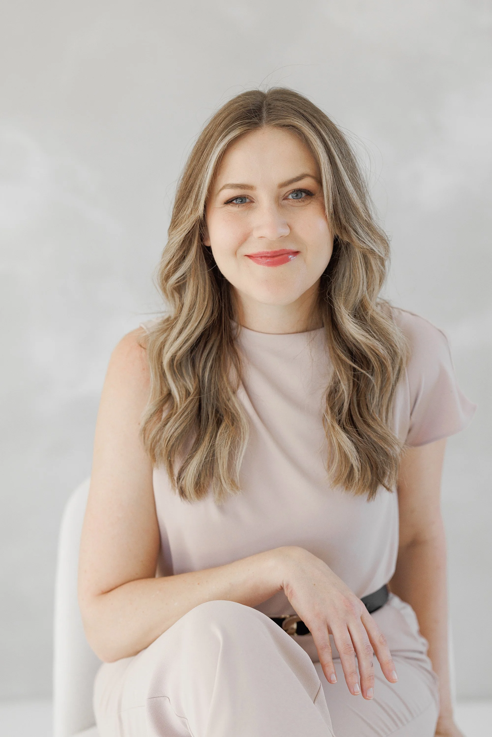 headshot of woman sitting in chair in denver studio