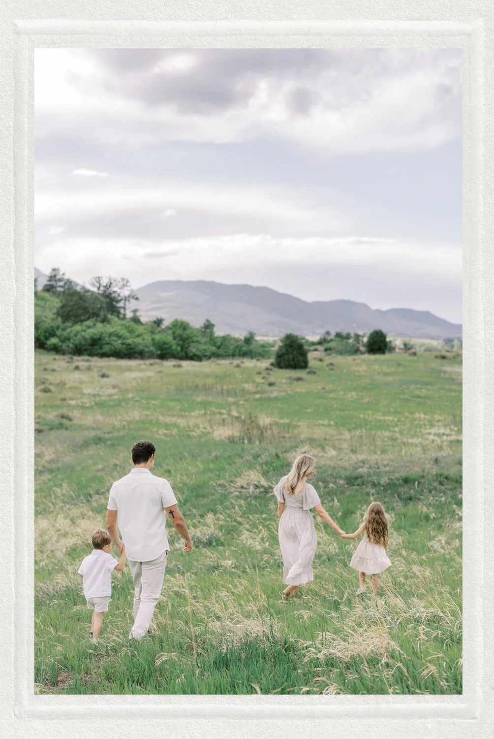 Family walking through field together during family session