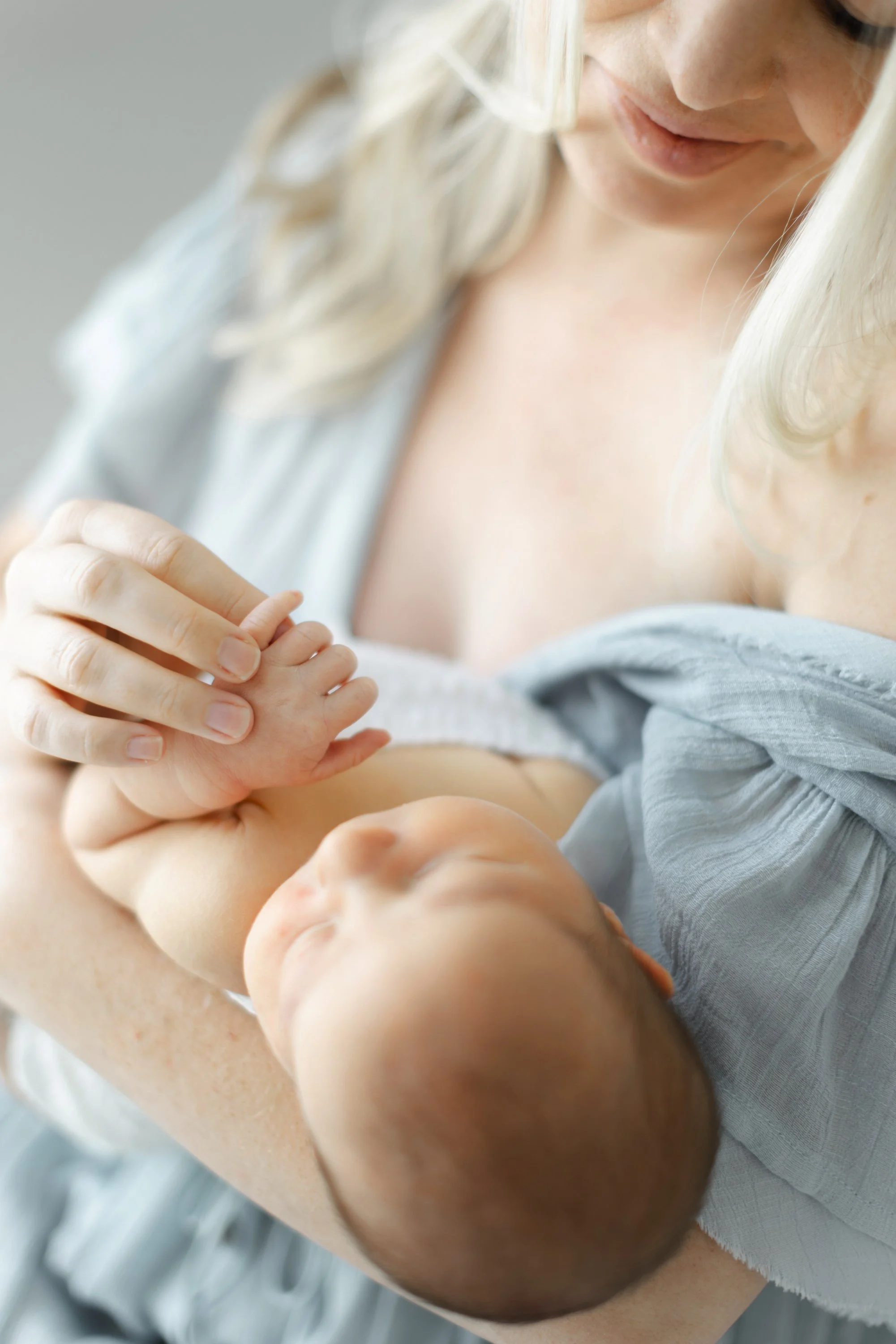 Mother rocking her newborn during a calm, intimate newborn photography session.