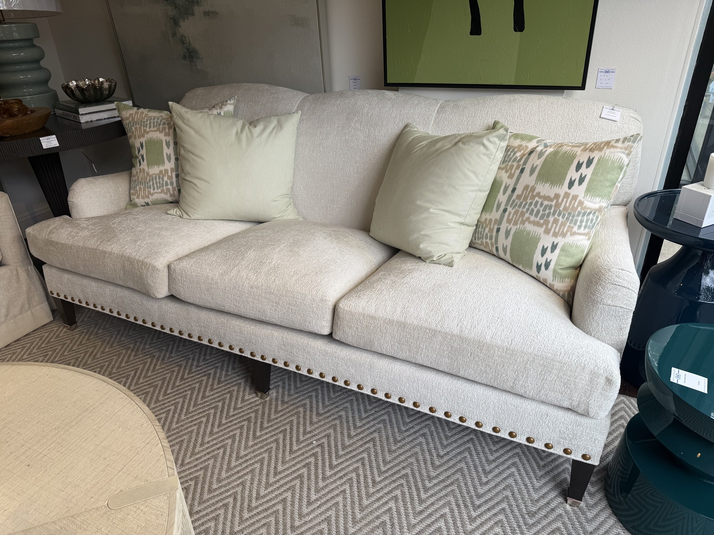 Charles Sofa in ivory fabric with plush cushions, nailhead trim, and green accent pillows, available at Donna Donaldson Interiors.
