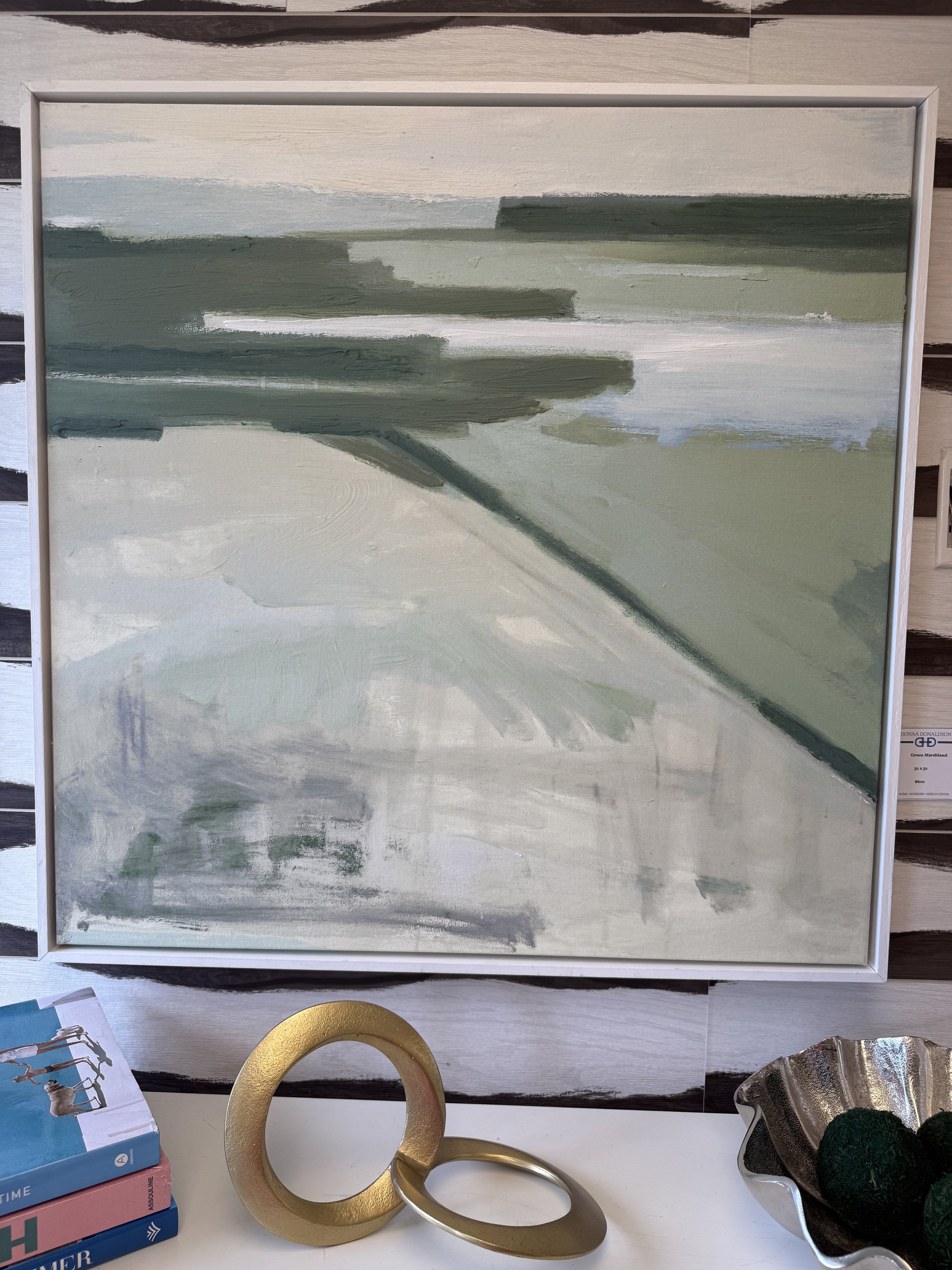 Framed 31x31 artwork titled “Green Marshland” featuring abstract layers of green and soft neutral tones, available at Donna Donaldson Interiors.