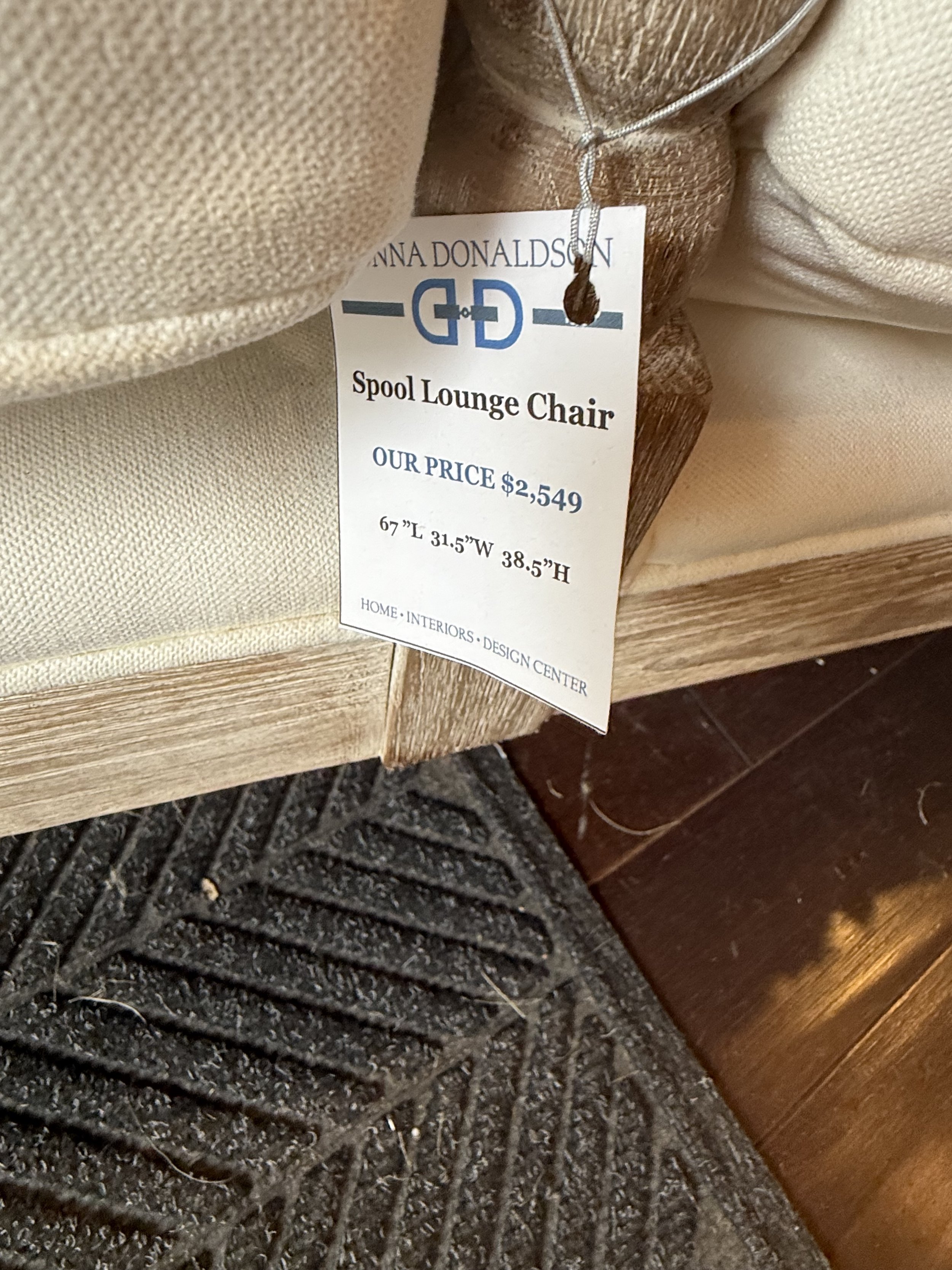 Spool Lounge Chair with hand-carved wood frame and ivory cushions, styled with a throw and geometric pillow, available at Donna Donaldson Interiors.